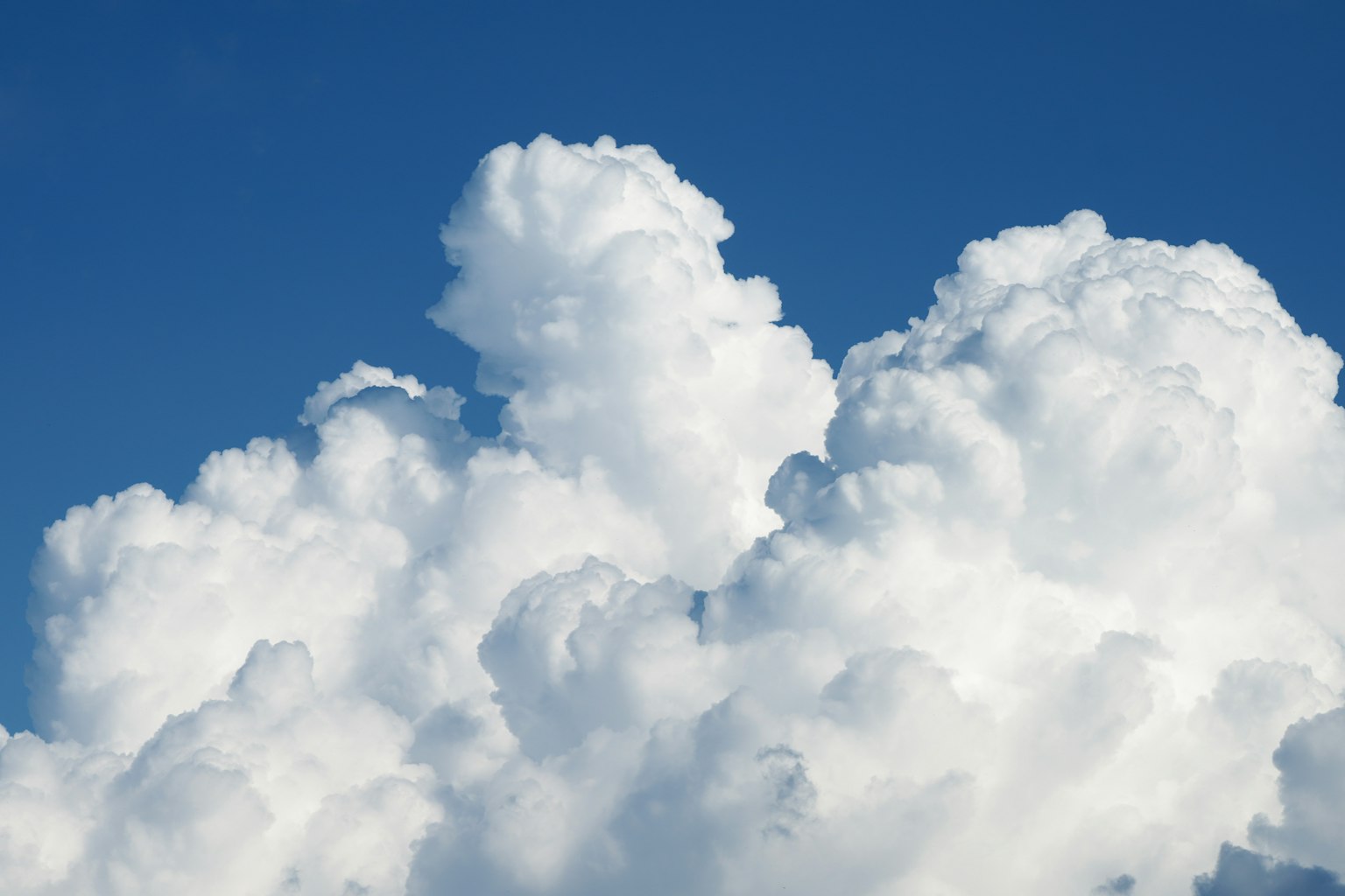 Fluffy weiße Wolken vor einem klaren blauen Himmel