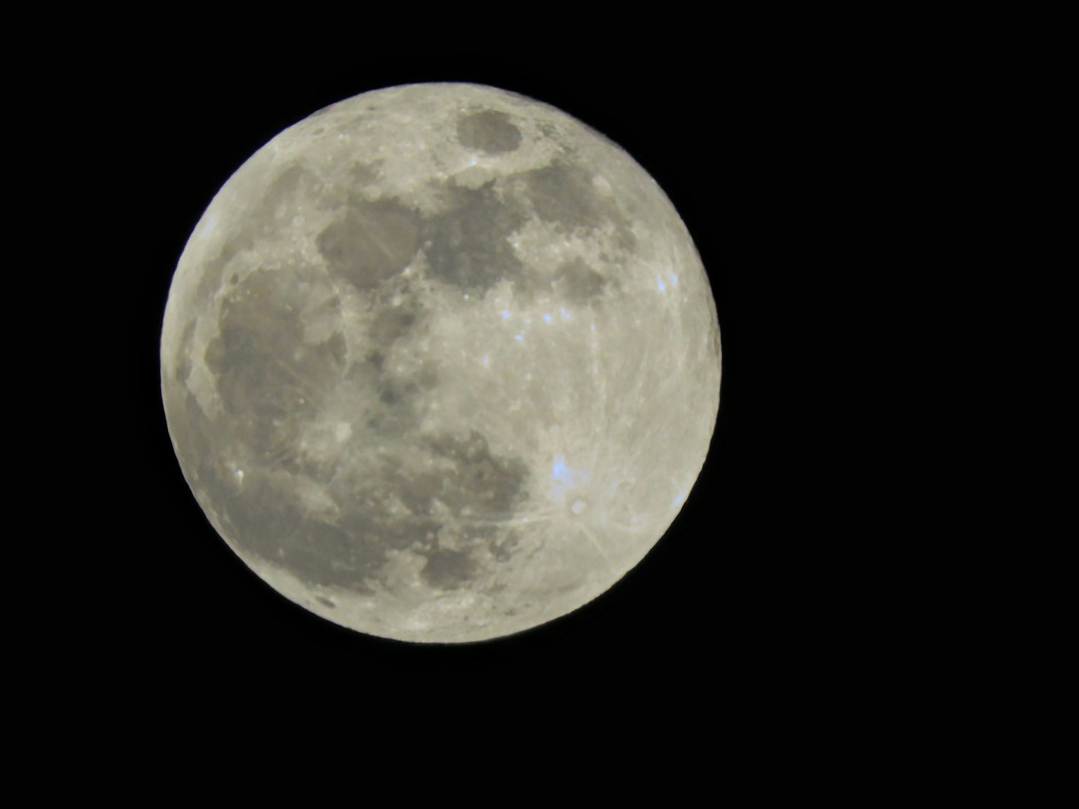 Helle Vollmond vor schwarzem Hintergrund
