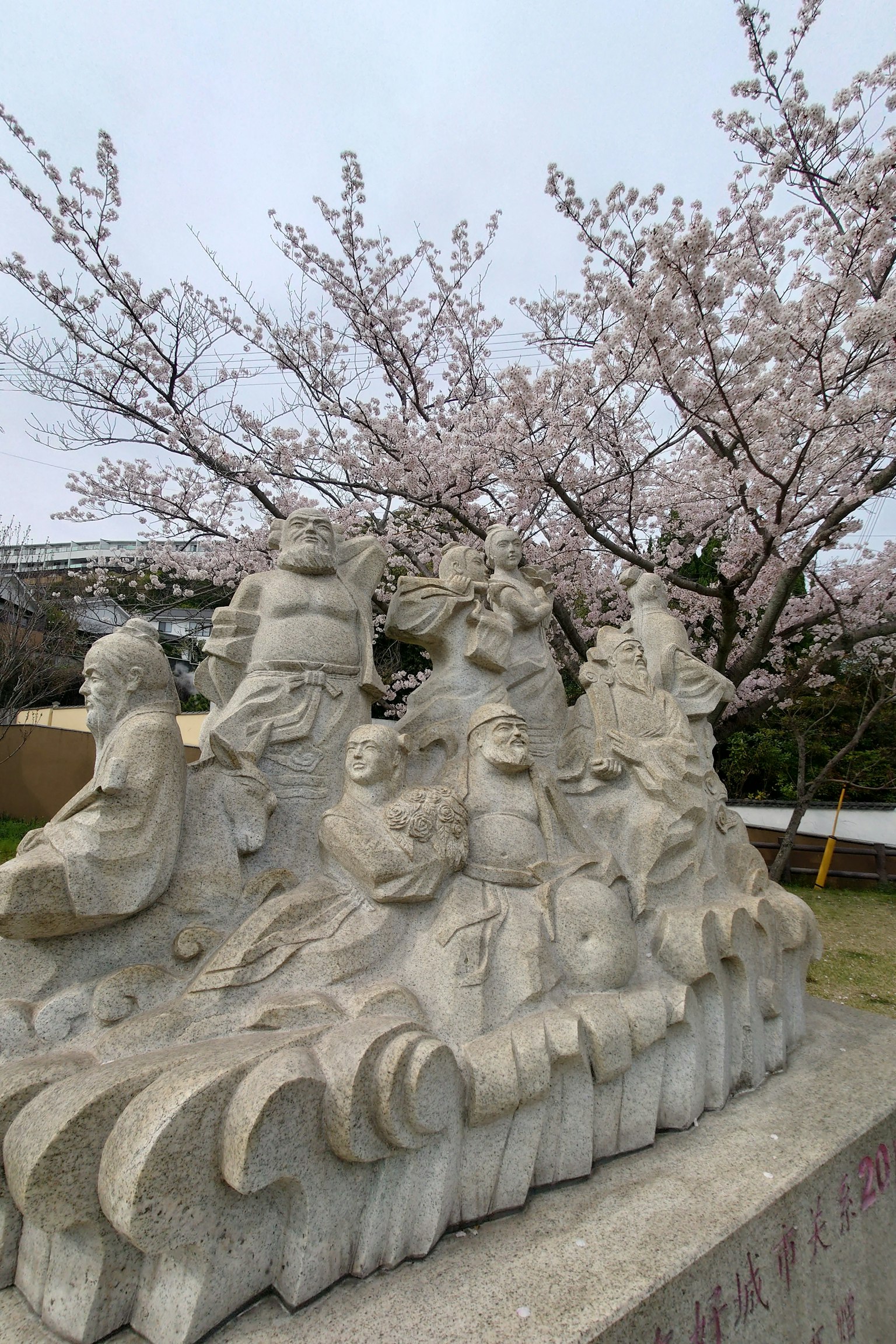 Steinskulpturengruppe unter einem Kirschbaum