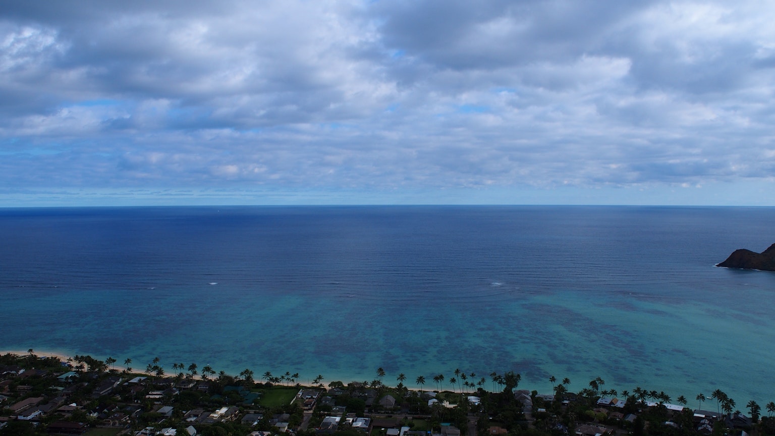 Pemandangan panorama lautan biru dan langit mendung
