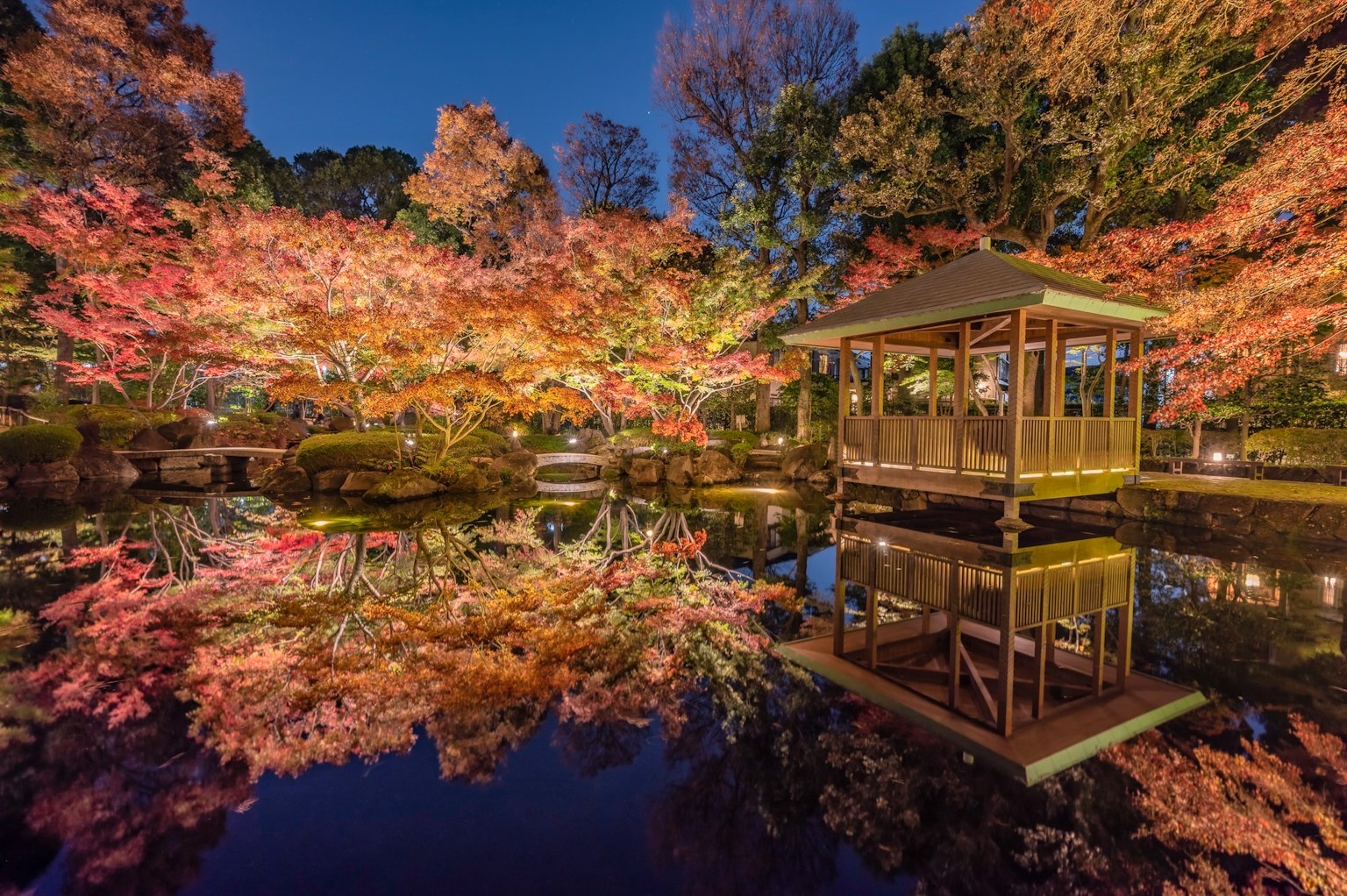 Vue pittoresque d'un étang avec des reflets de feuillage d'automne et un pavillon