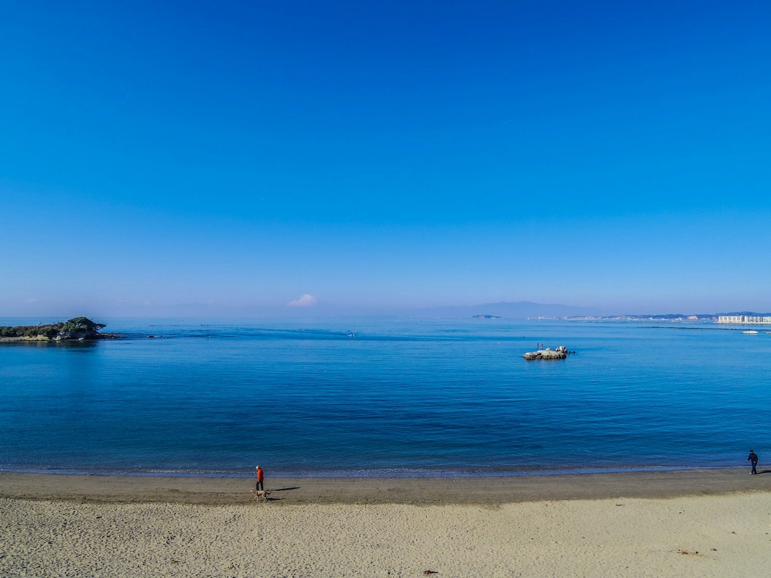 ทิวทัศน์ชายหาดกับท้องฟ้าสีฟ้าและทะเลสงบ