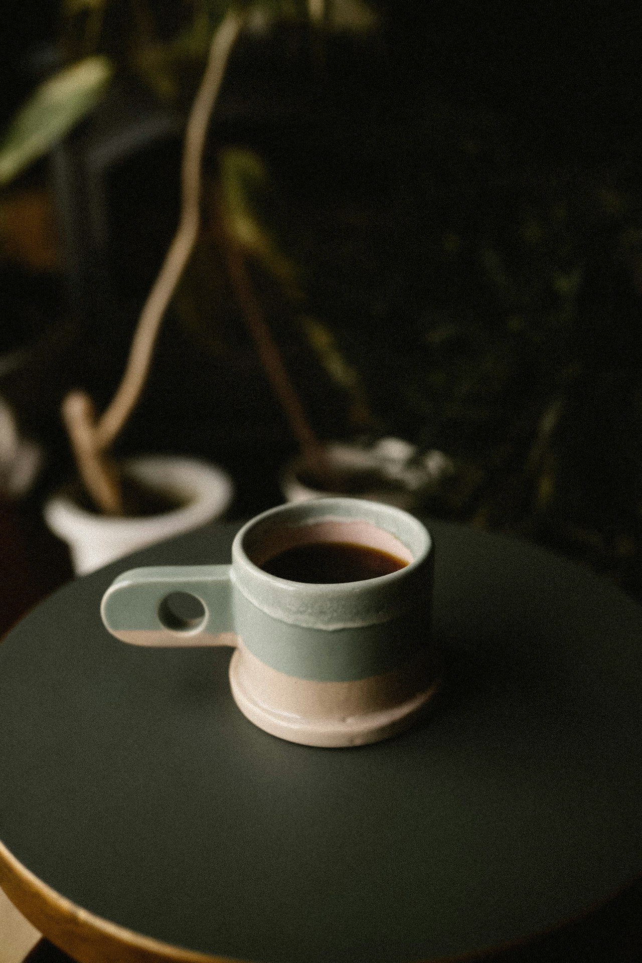 屋外のテーブルに置かれたマグカップのコーヒー