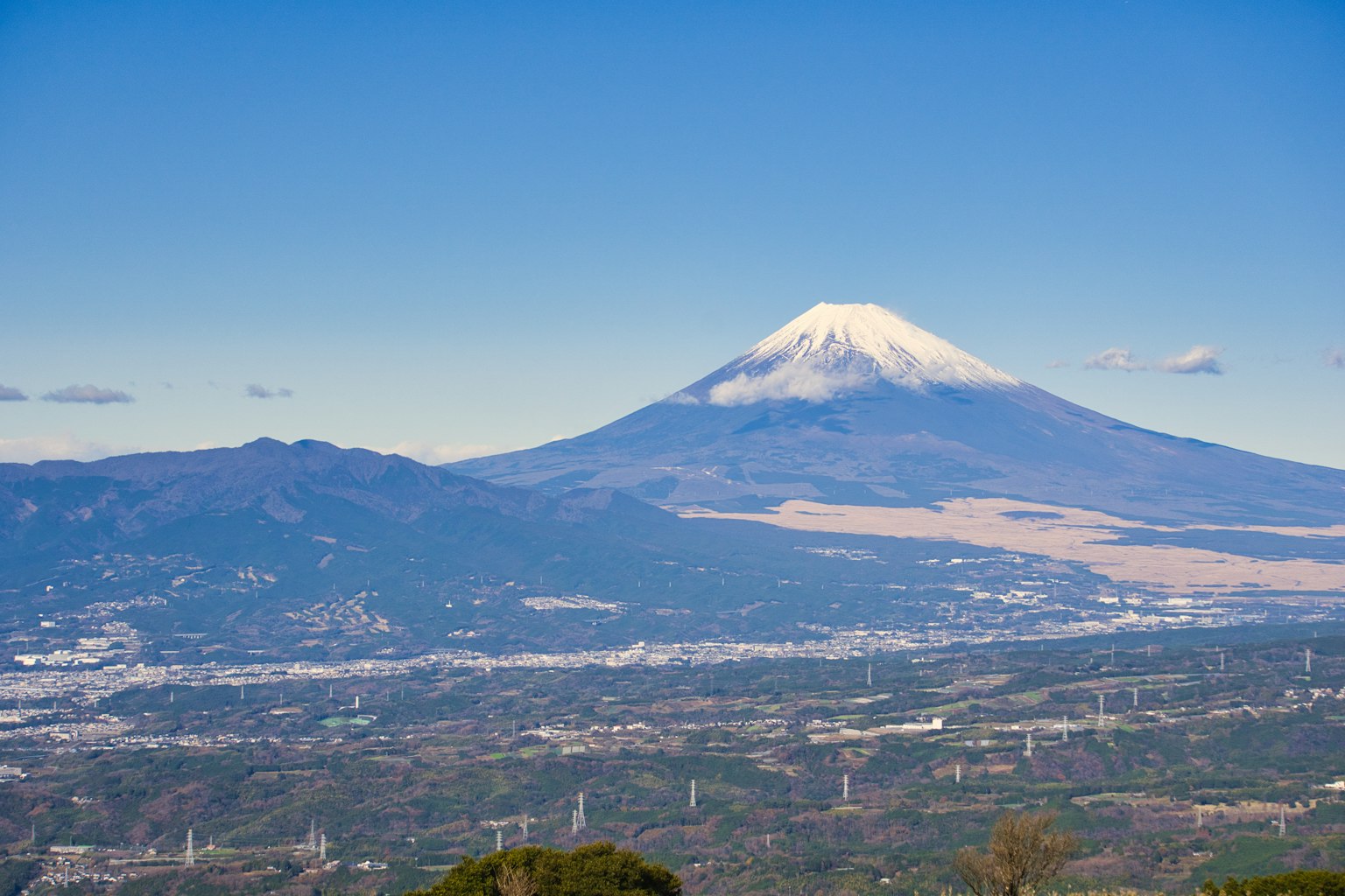 ทิวทัศน์ที่สวยงามของภูเขาฟูจิพร้อมท้องฟ้าสีฟ้าและยอดเขาที่มีหิมะ