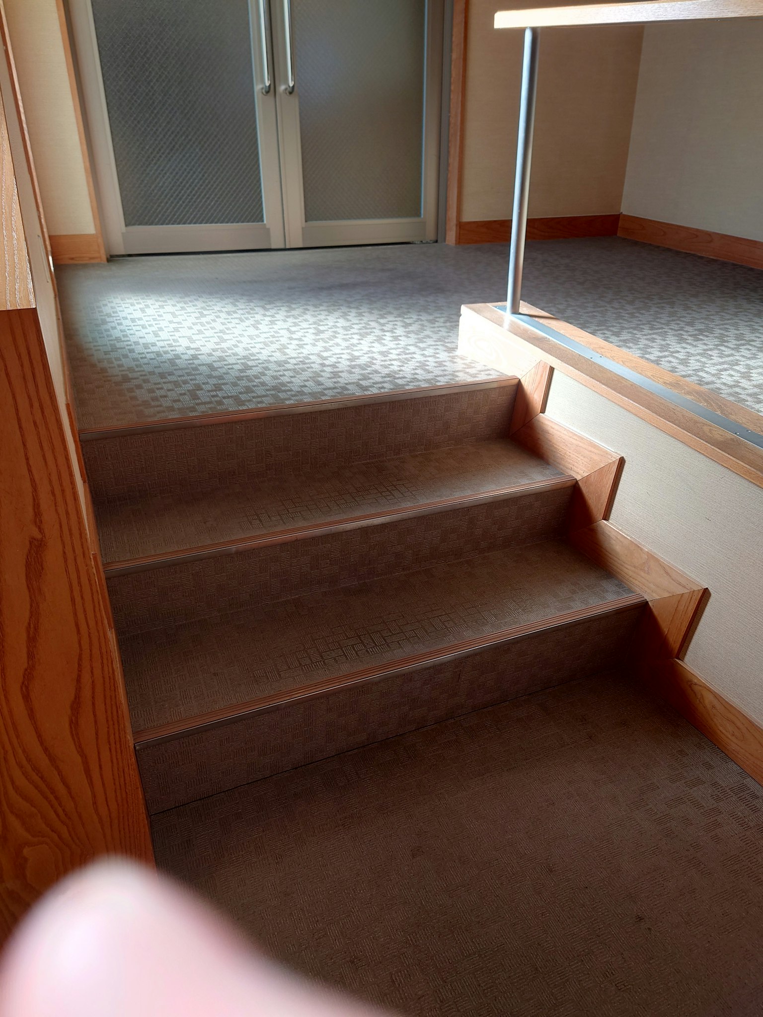 Vista interna di scale con moquette e corrimano in legno