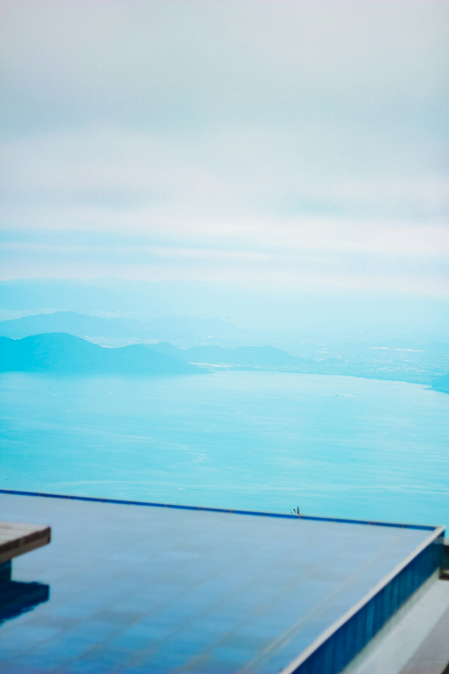 Weite blaue Landschaft mit Wasser und Himmel und Poolterrasse