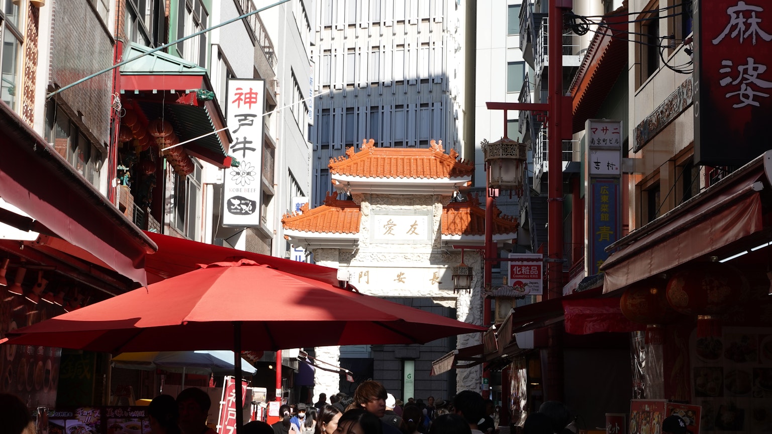 Scène de rue animée avec des parasols rouges et une architecture de Chinatown