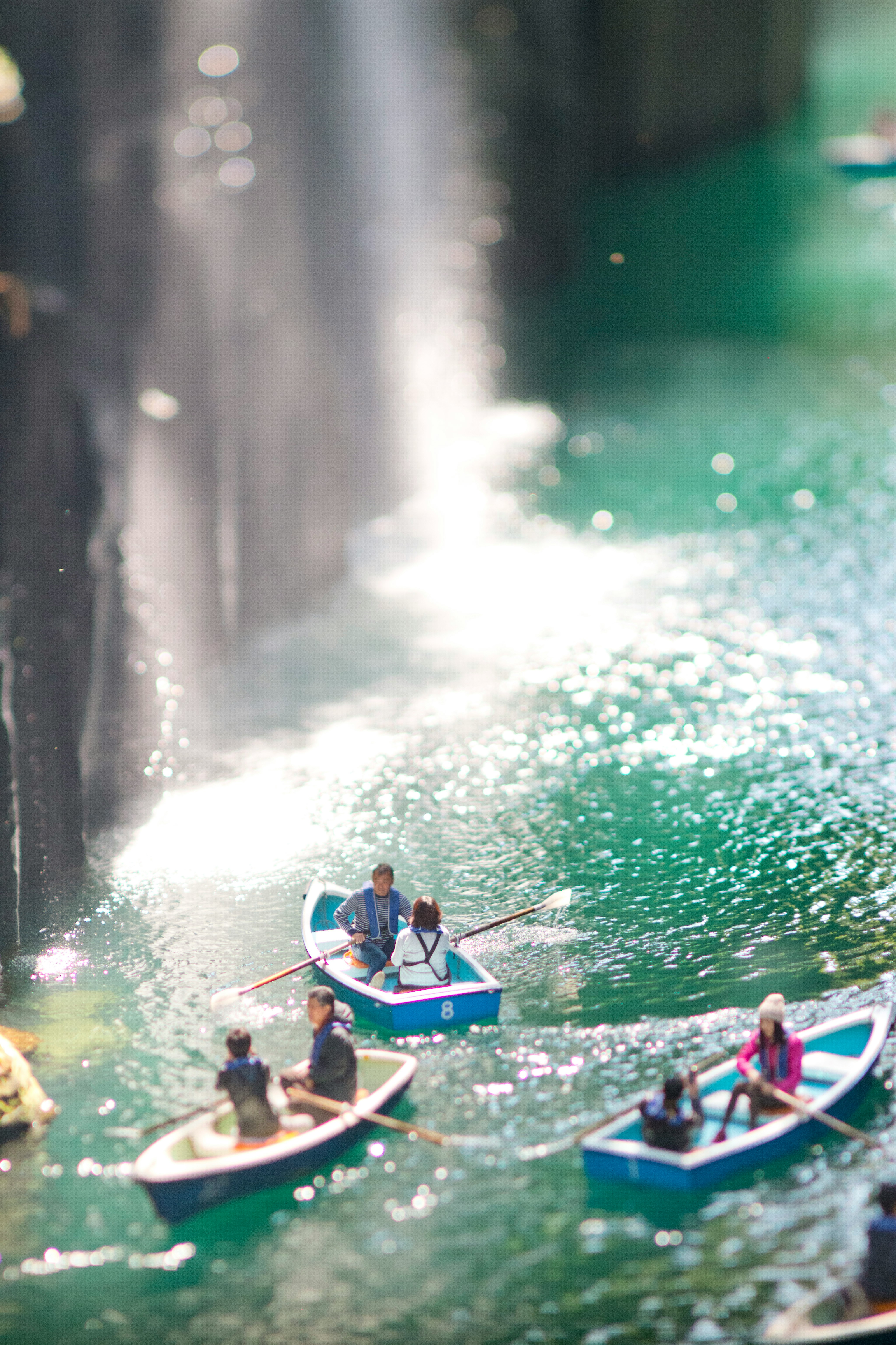 青いボートに乗る人々が美しい緑の水面で楽しんでいる風景
