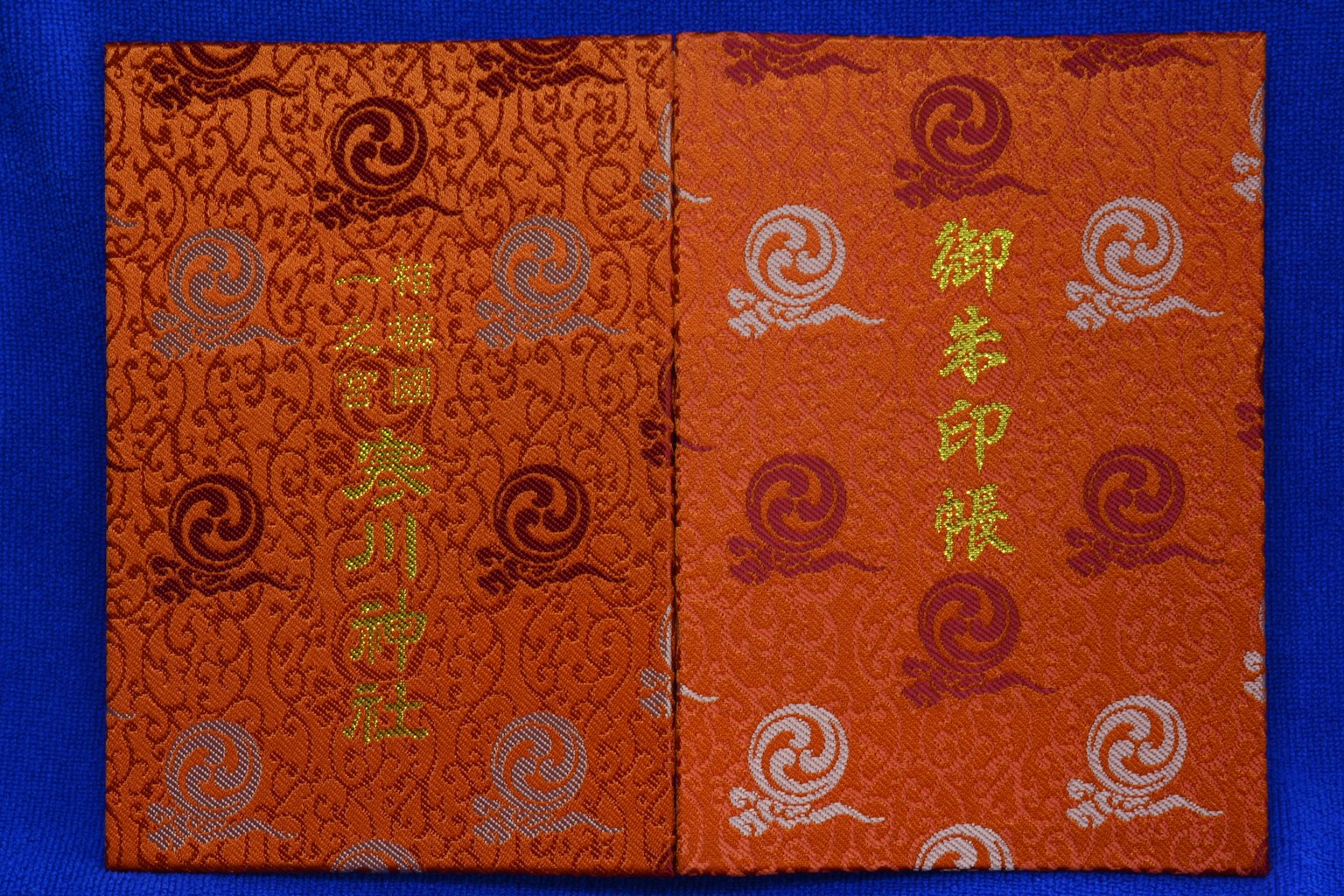 Dekorative orange Buchdeckel mit spiralförmigen Mustern und goldenem Text