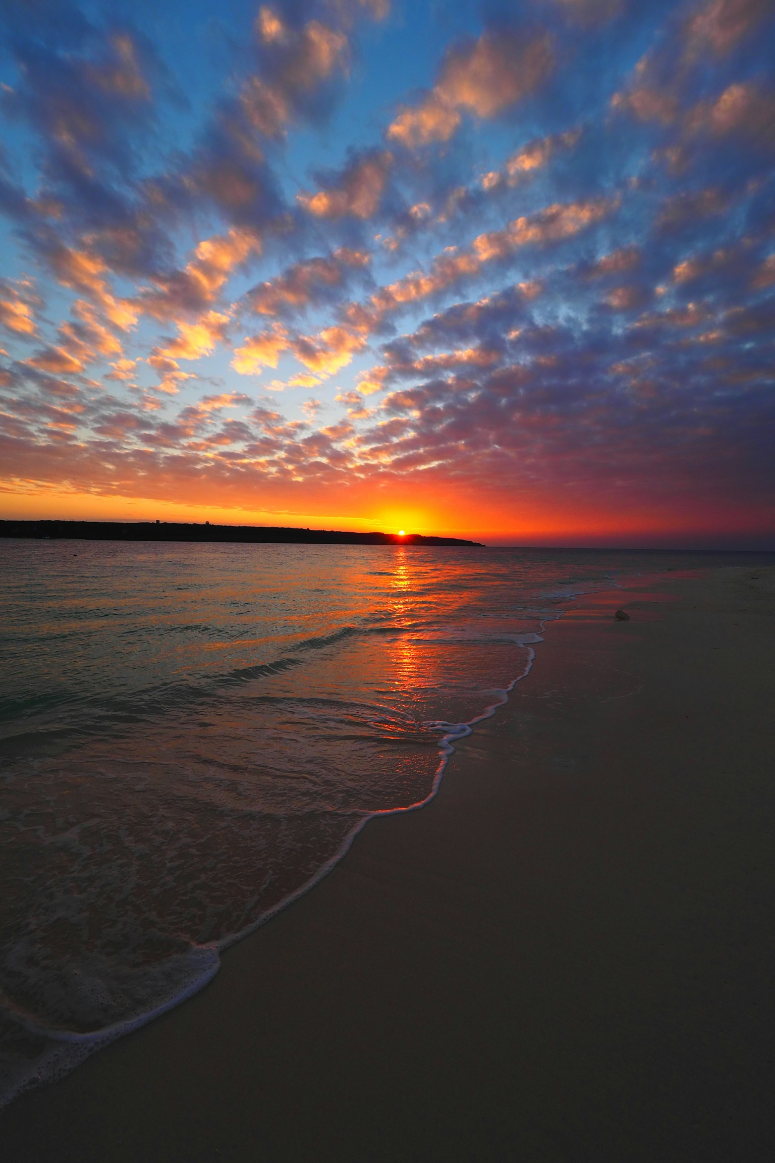 Beautiful beach sunset with waves lapping on the sandy shore