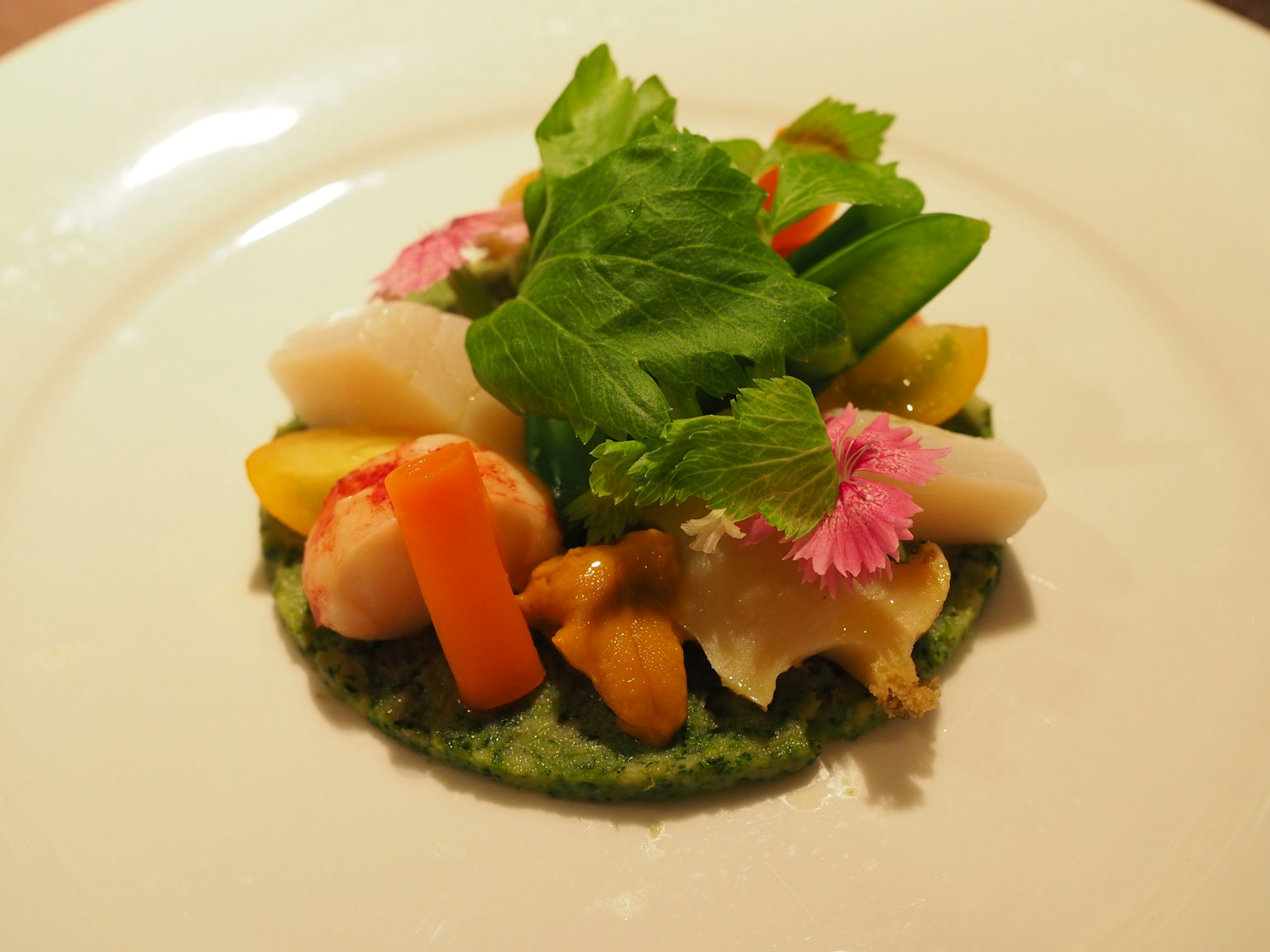 Un plat magnifiquement présenté avec des légumes colorés et des herbes