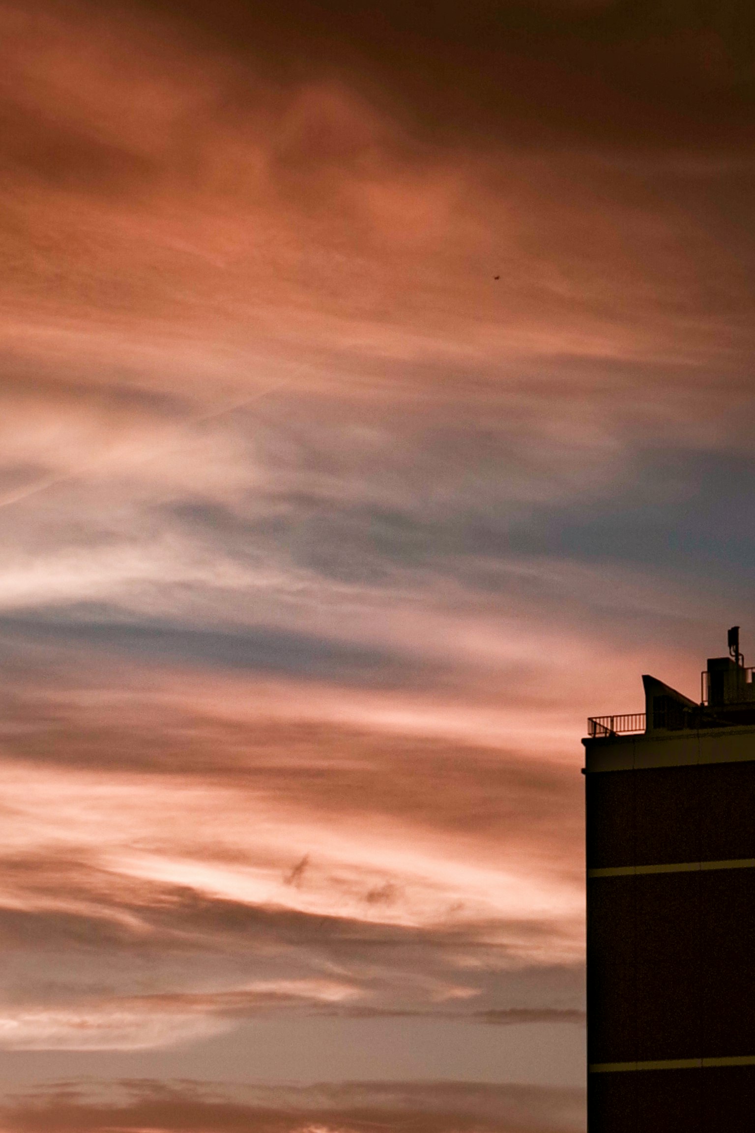 Silhouette d'un bâtiment contre un ciel de coucher de soleil aux couleurs vives
