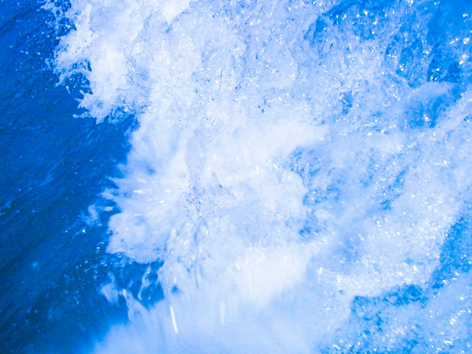 Close-up of splashing water and bubbles in blue ocean