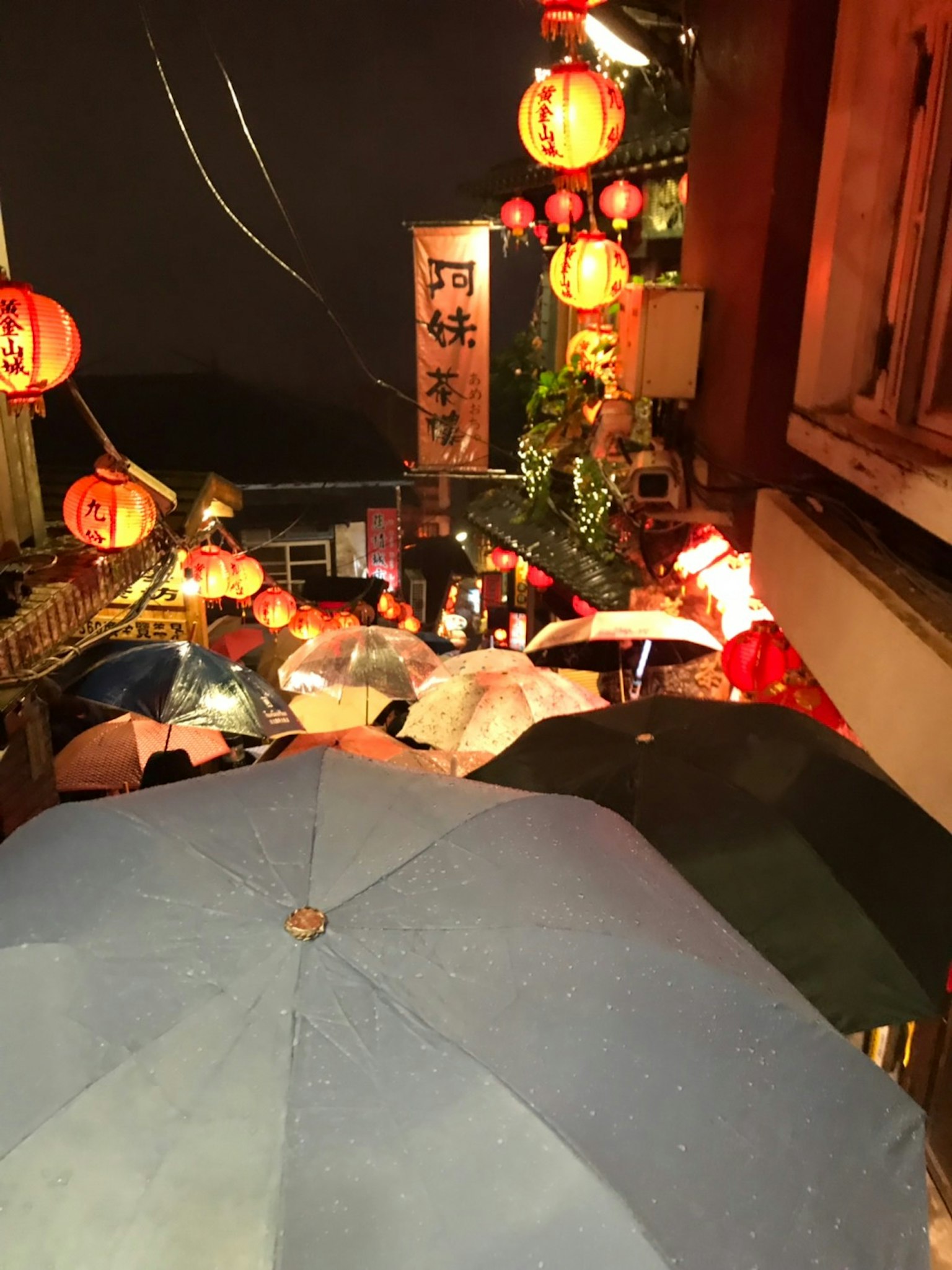 Una scena vivace di ombrelli e lanterne che illuminano una strada notturna