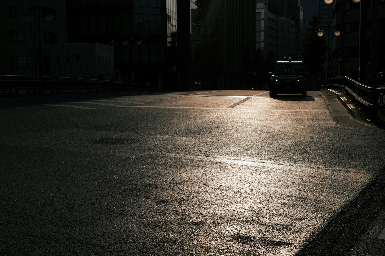 Une rue sombre de la ville avec des reflets de lumière et une voiture