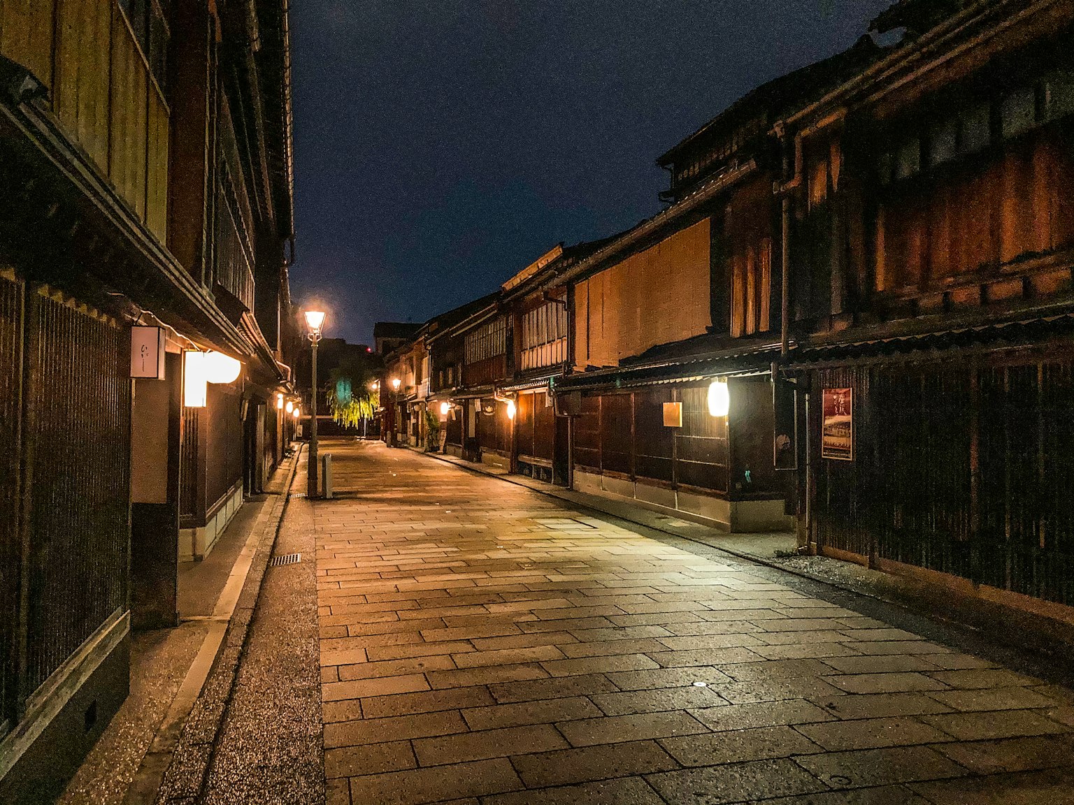 Strada tranquilla di notte con edifici in legno tradizionali e pavimentazione in ciottoli