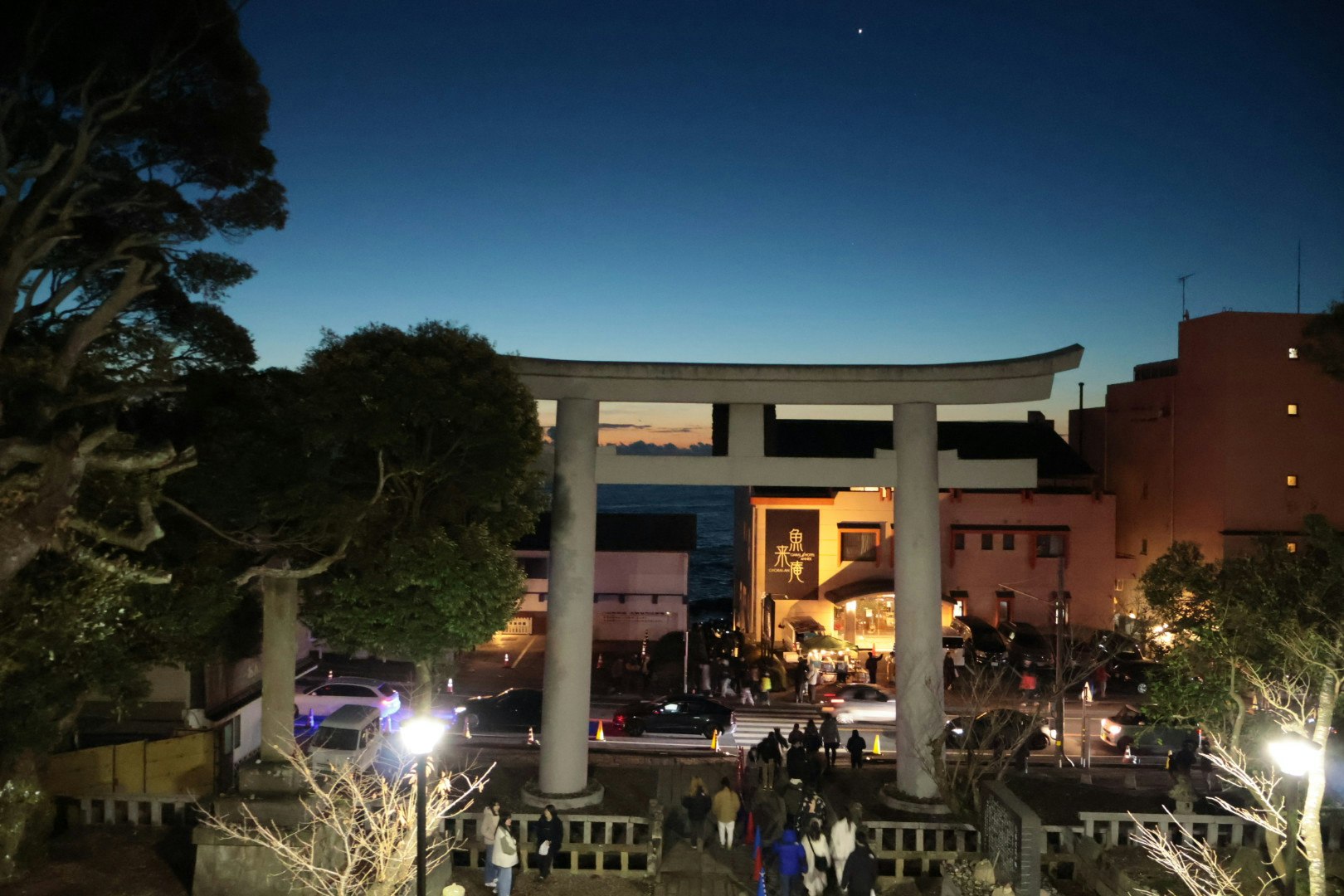 夜晚室外聚会，灯光照亮的柱子与建筑前景