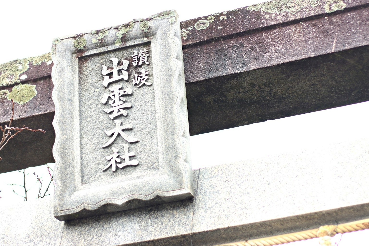 Schild von Izumo Taisha an einem Steintorii
