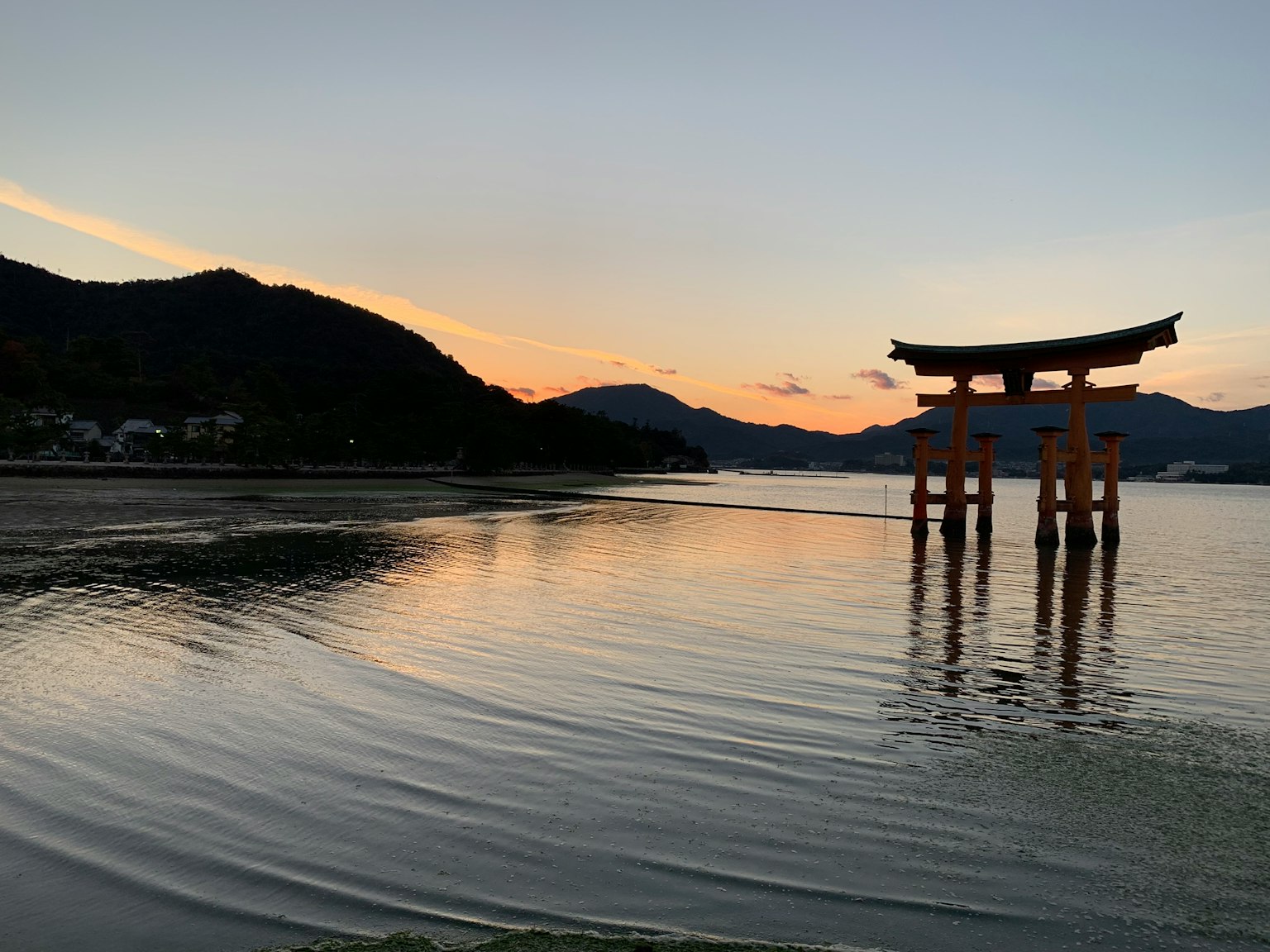 아름다운 석양을 배경으로 한 조용한 물가의 토리이 게이트