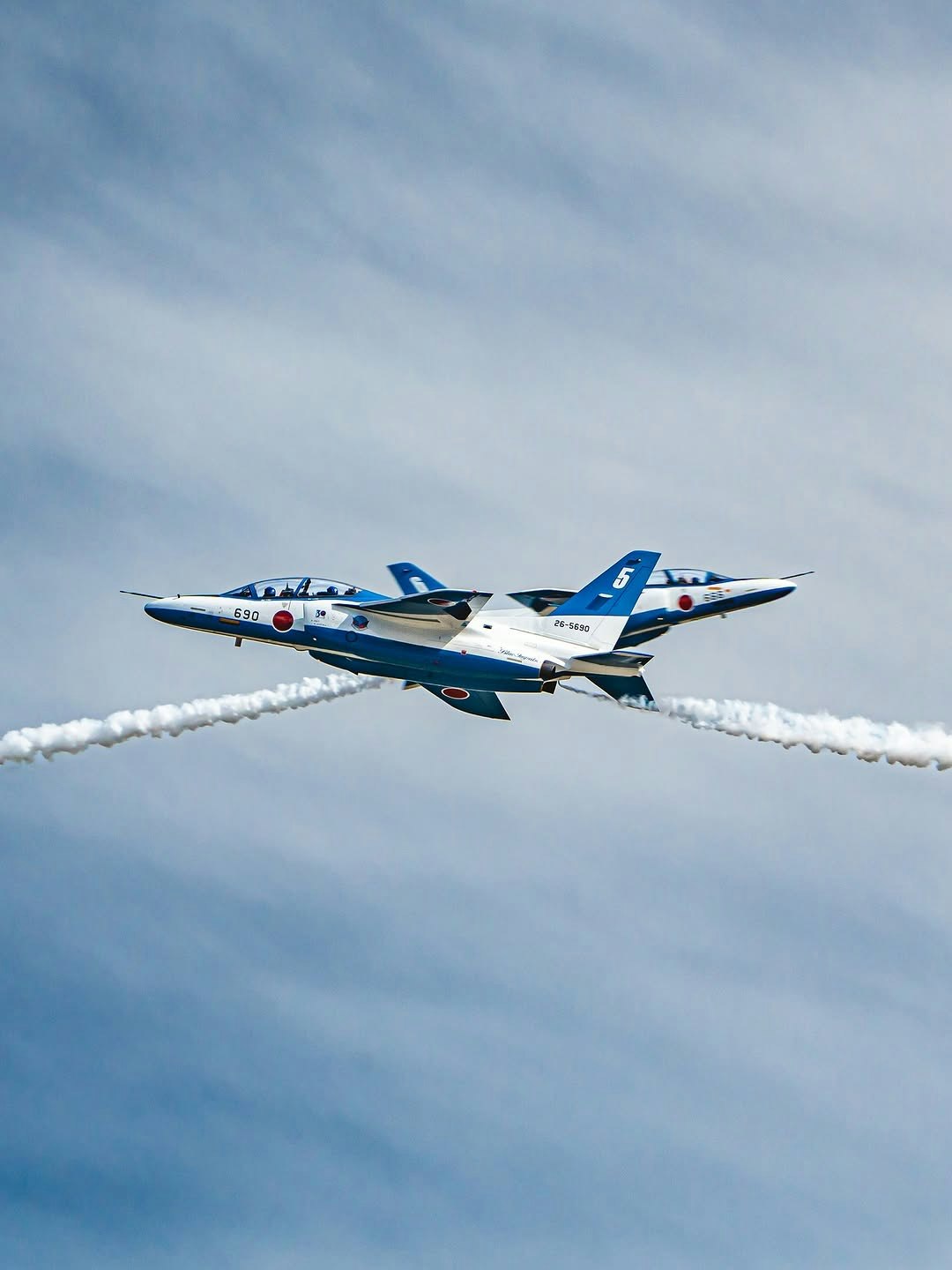 ブルーインパルスのオポジットコンティニュアスロールを飛行中に撮影した戦闘機の編隊