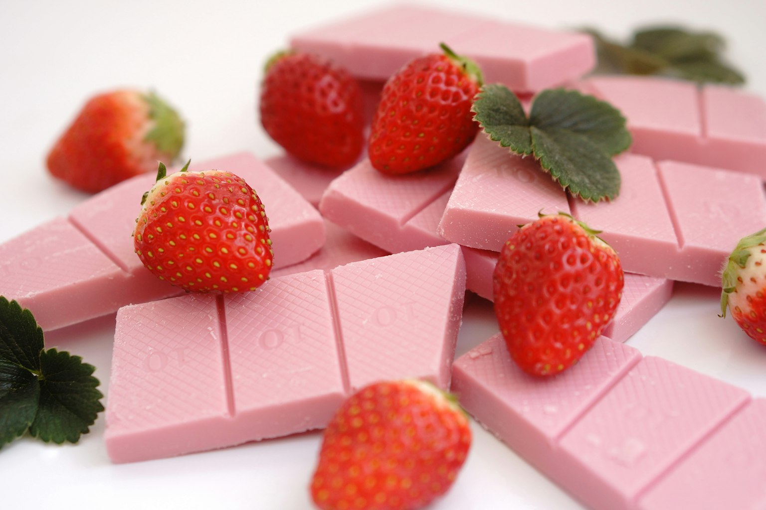 Rosa Schokoladenstücke mit frischen Erdbeeren