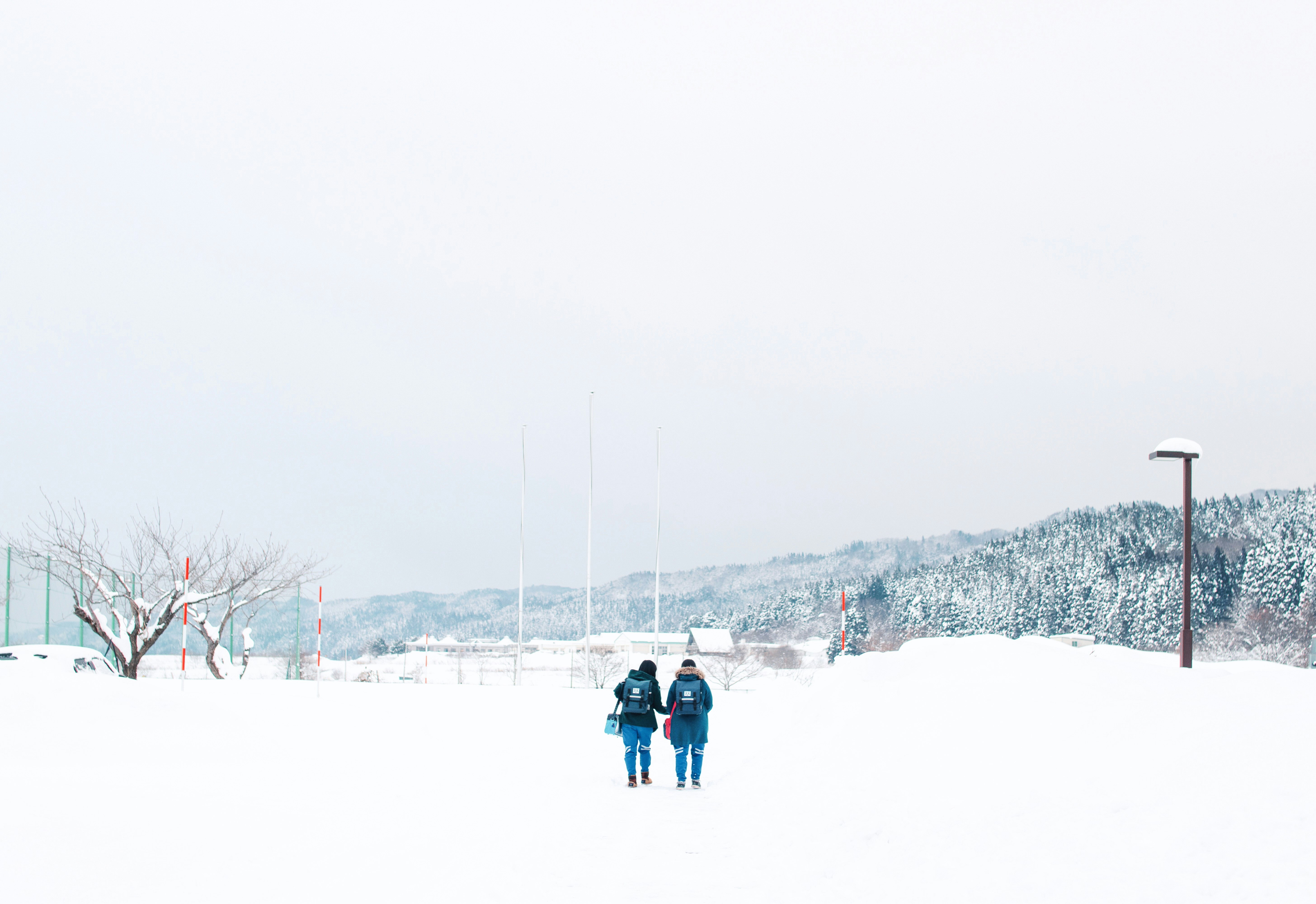 雪原を歩く2人の人物