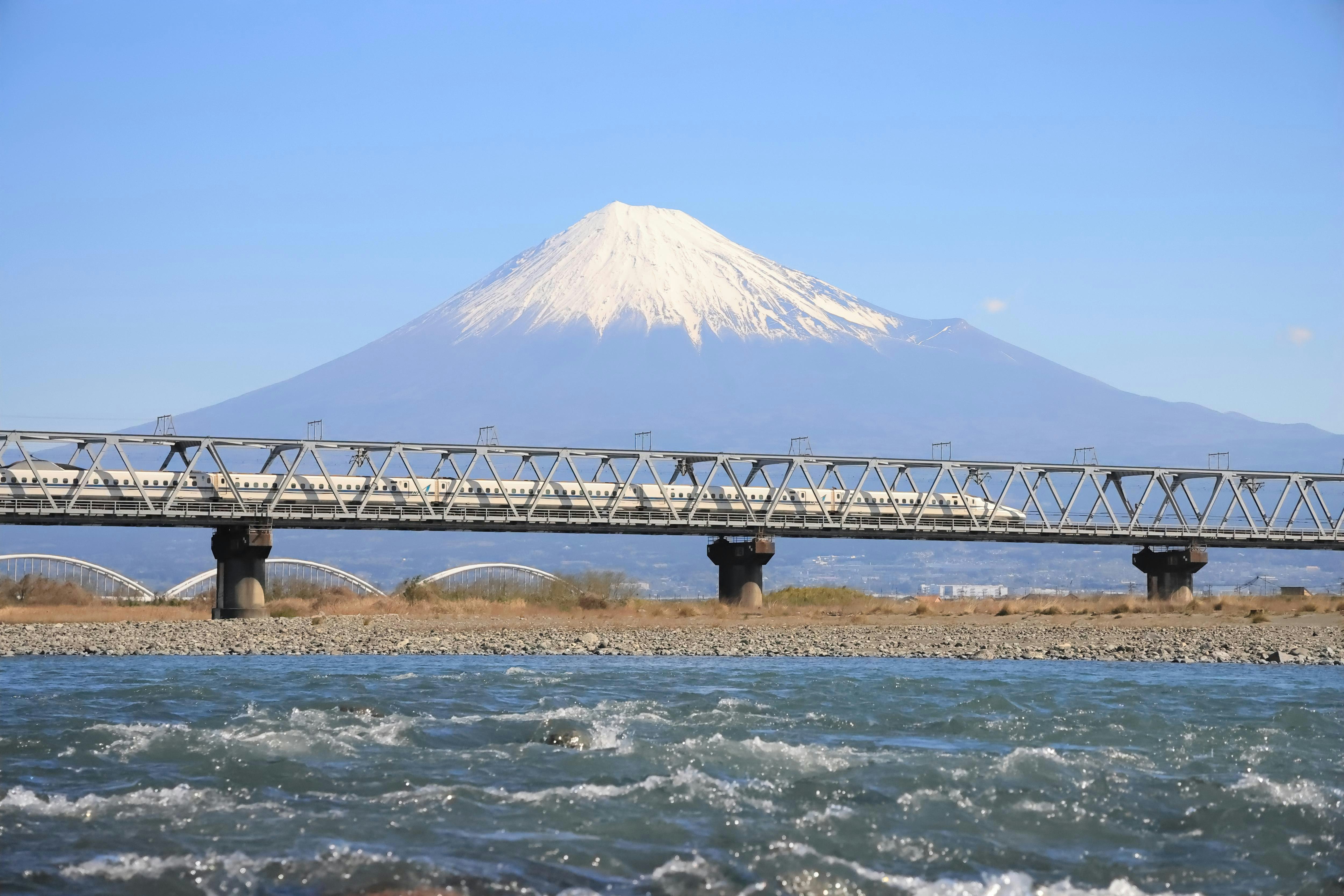 Train Shinkansen passant sur le fleuve Fuji avec le mont Fuji en arrière-plan