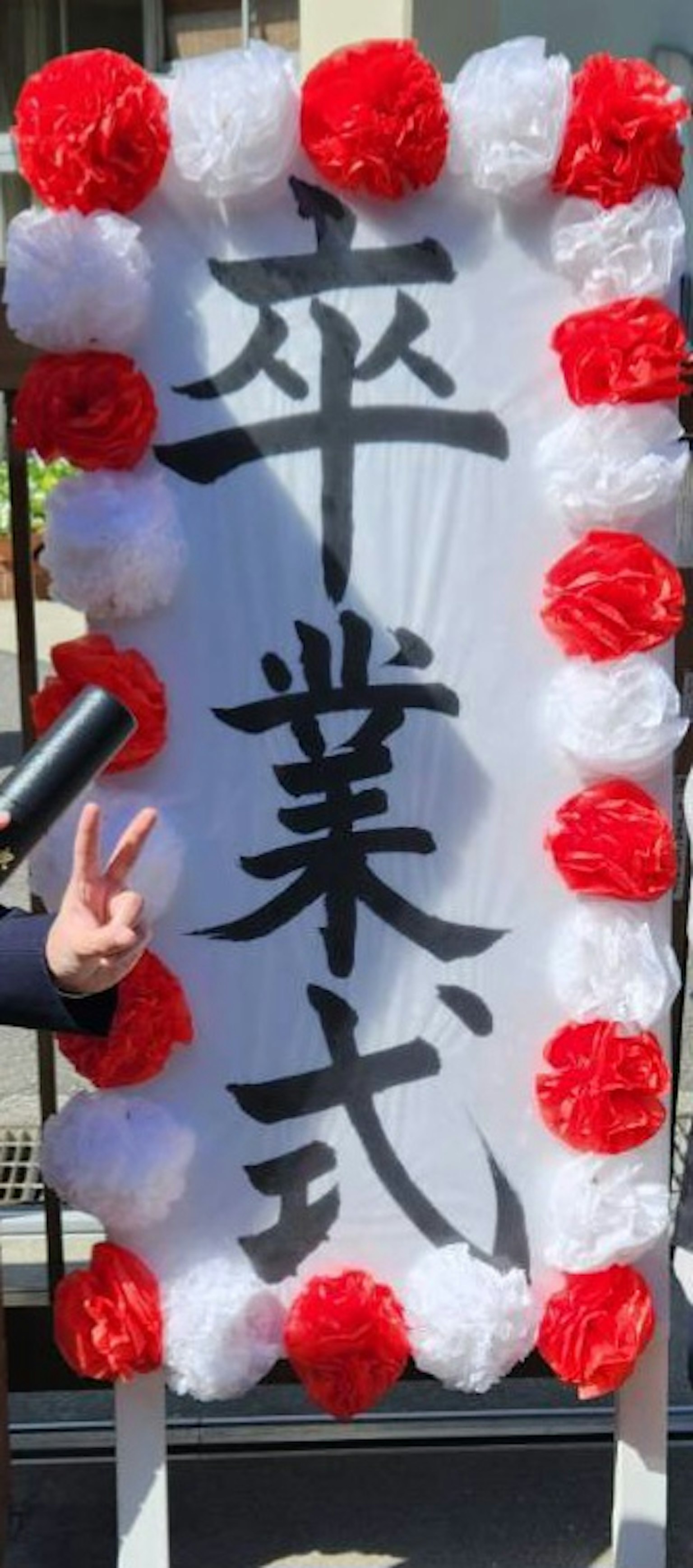 一個慶祝畢業的裝飾性標誌，上面用大字寫著'畢業典禮'