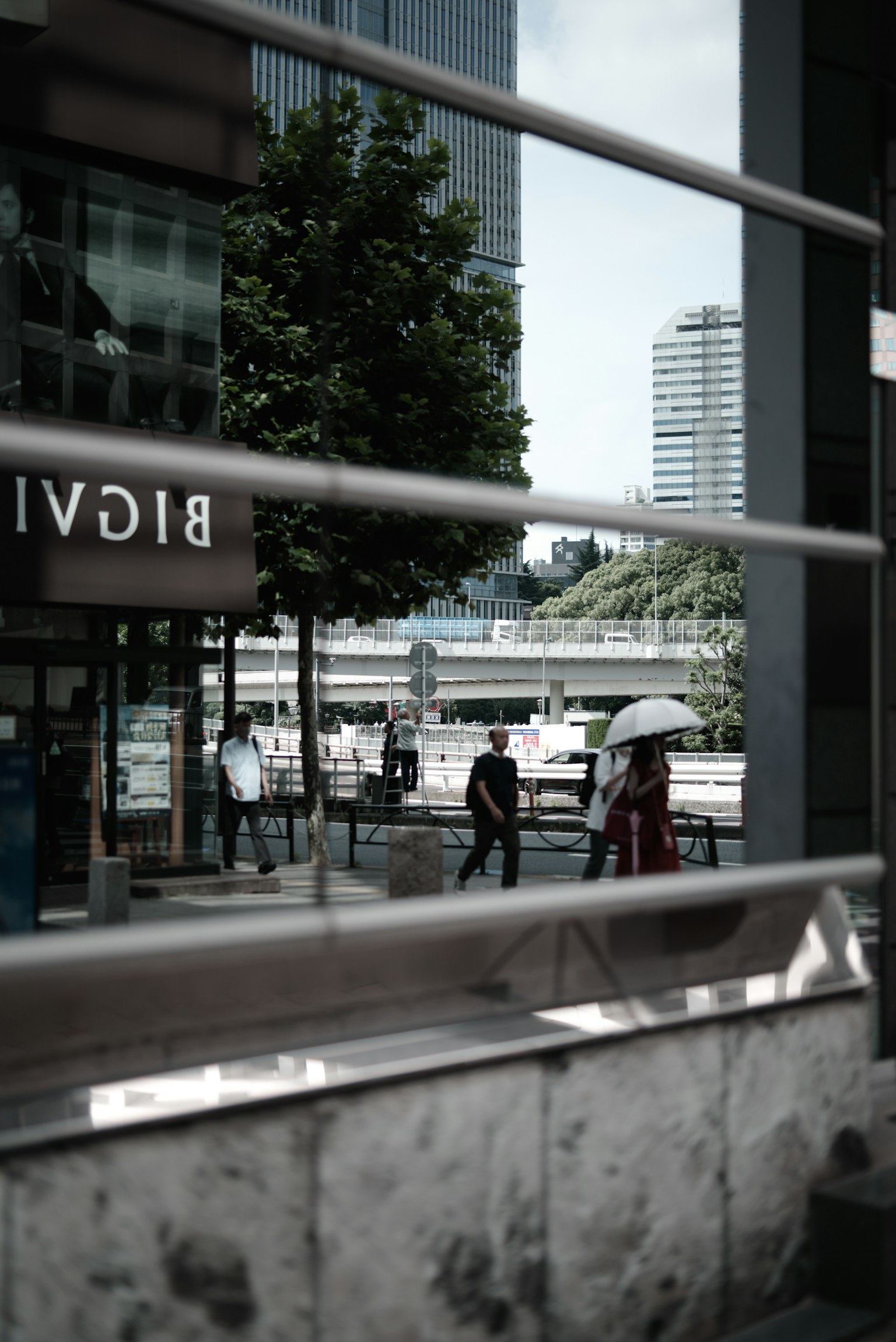 Urban landscape reflected in glass with pedestrians