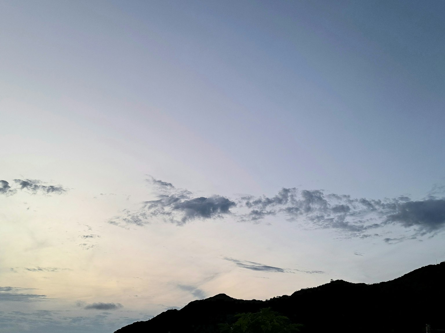 青空と山のシルエットがある風景