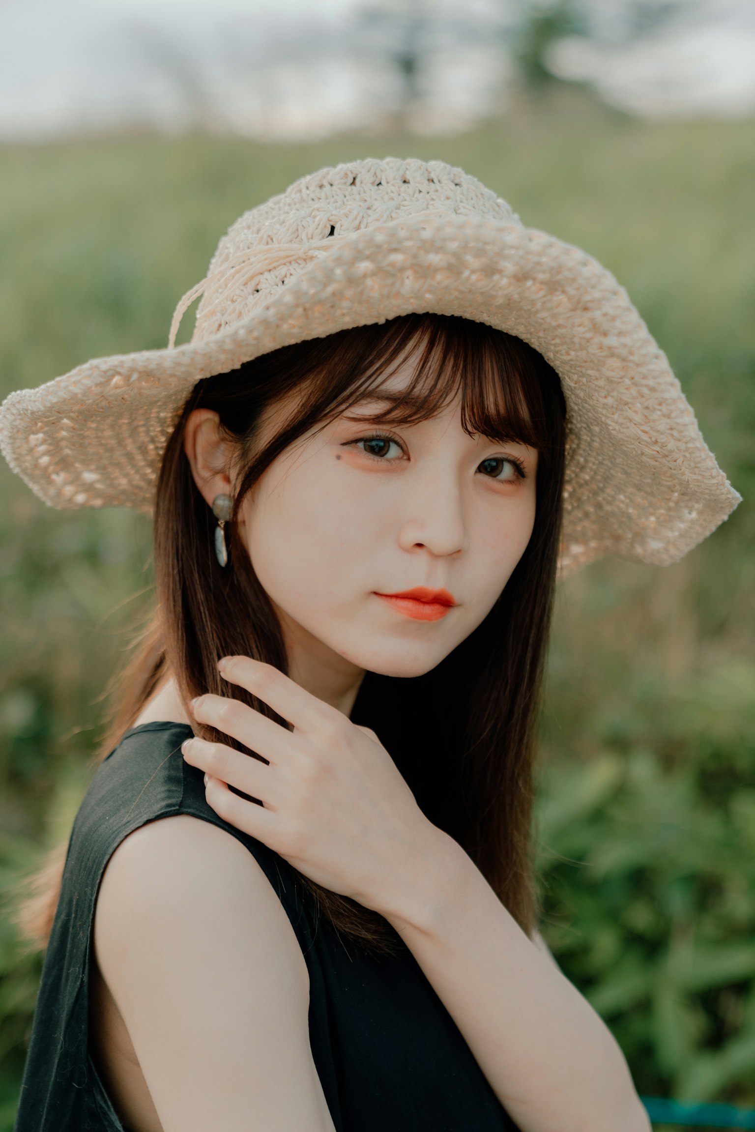 풀밭에서 밀짚모자를 쓴 여성의 초상화