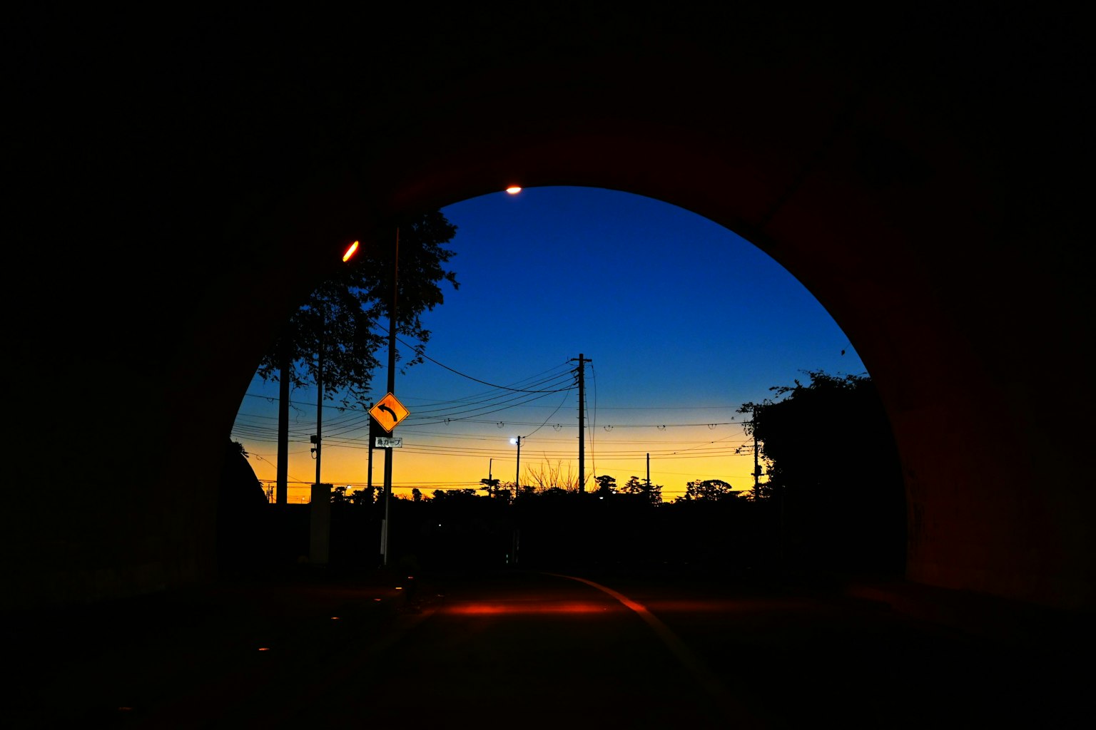 Schöner Sonnenuntergangshimmel, gesehen durch den Bogen eines Tunnels