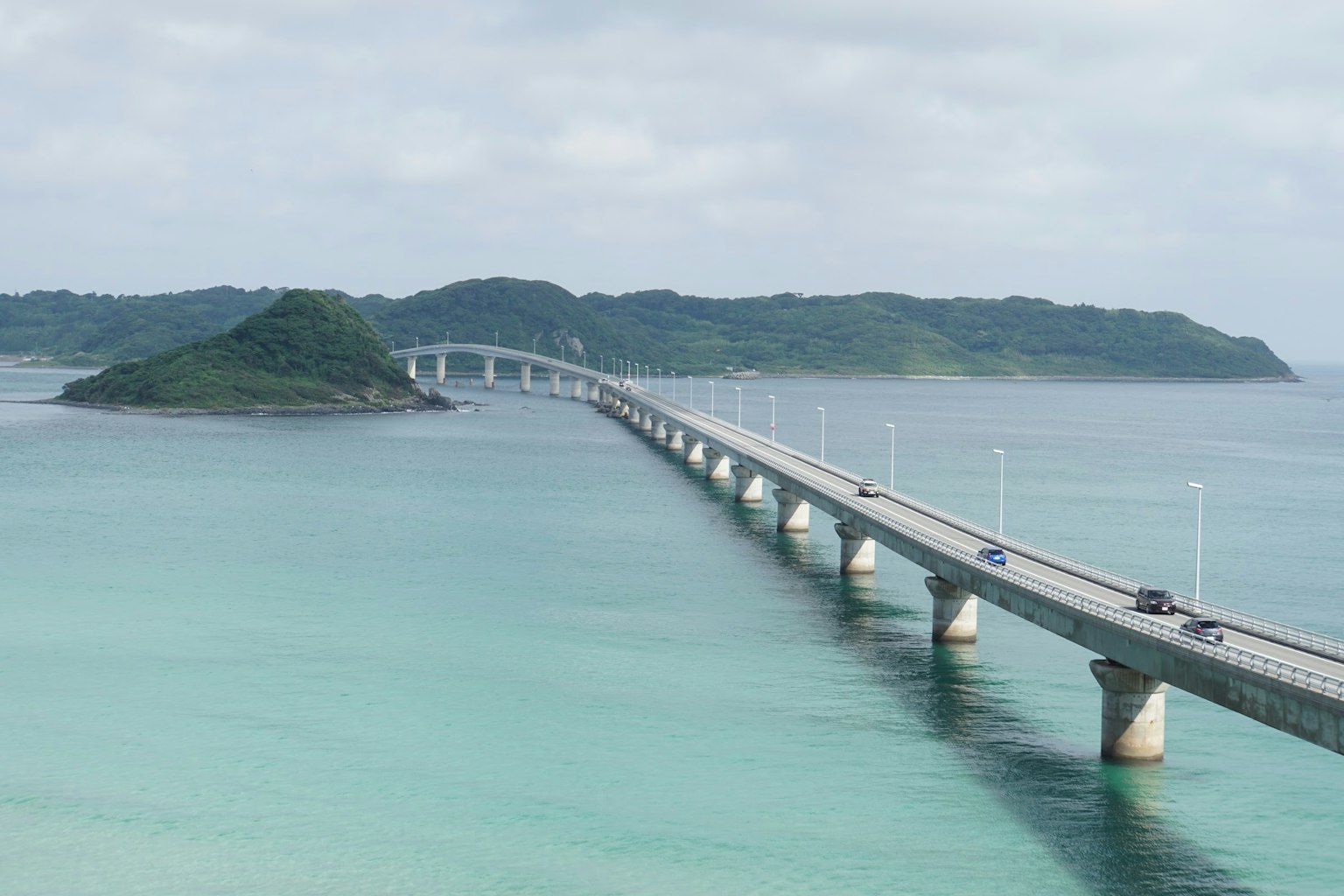 Scenic bridge extending over turquoise waters towards a small island