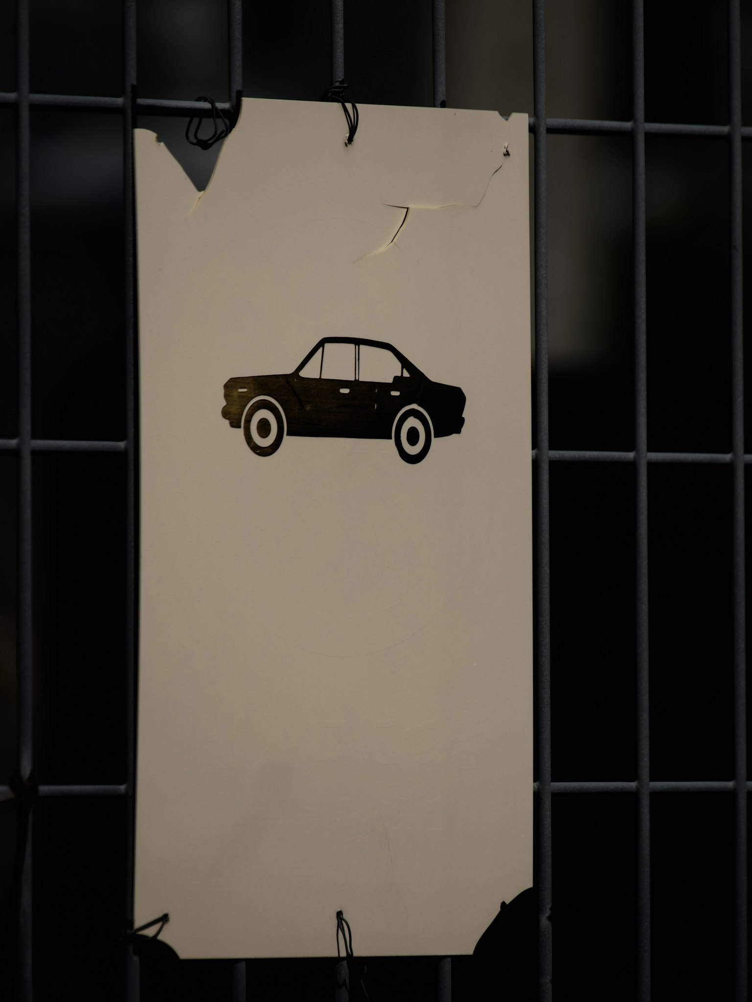 Un vieux panneau avec une silhouette de voiture noire