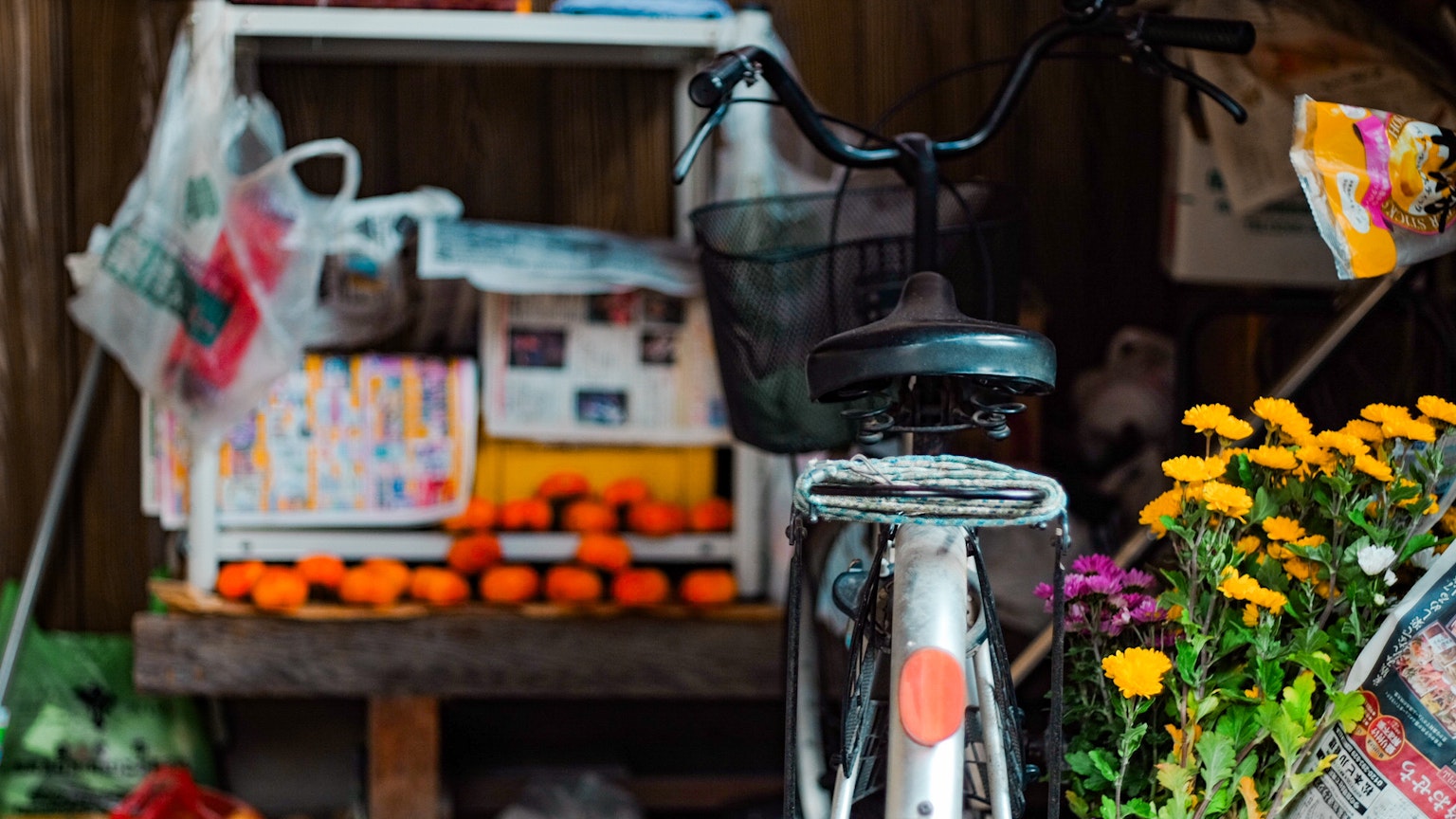 Sepeda di samping stand kecil dengan jeruk dan bunga