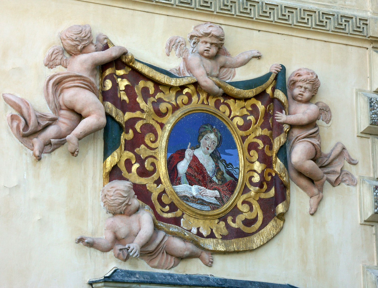 Pintura decorativa de una figura rodeada de querubines en una pared