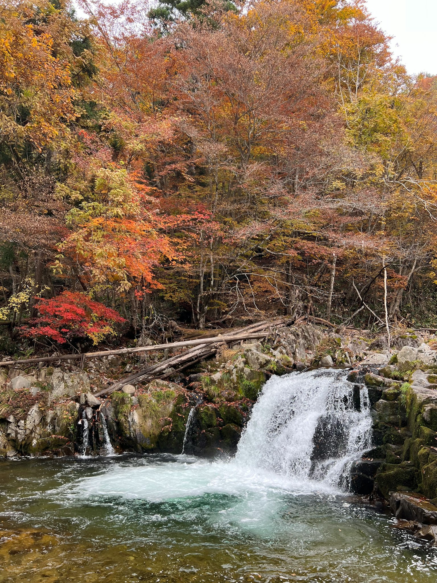 Scenic river landscape with vibrant autumn leaves small waterfall and calm water surface