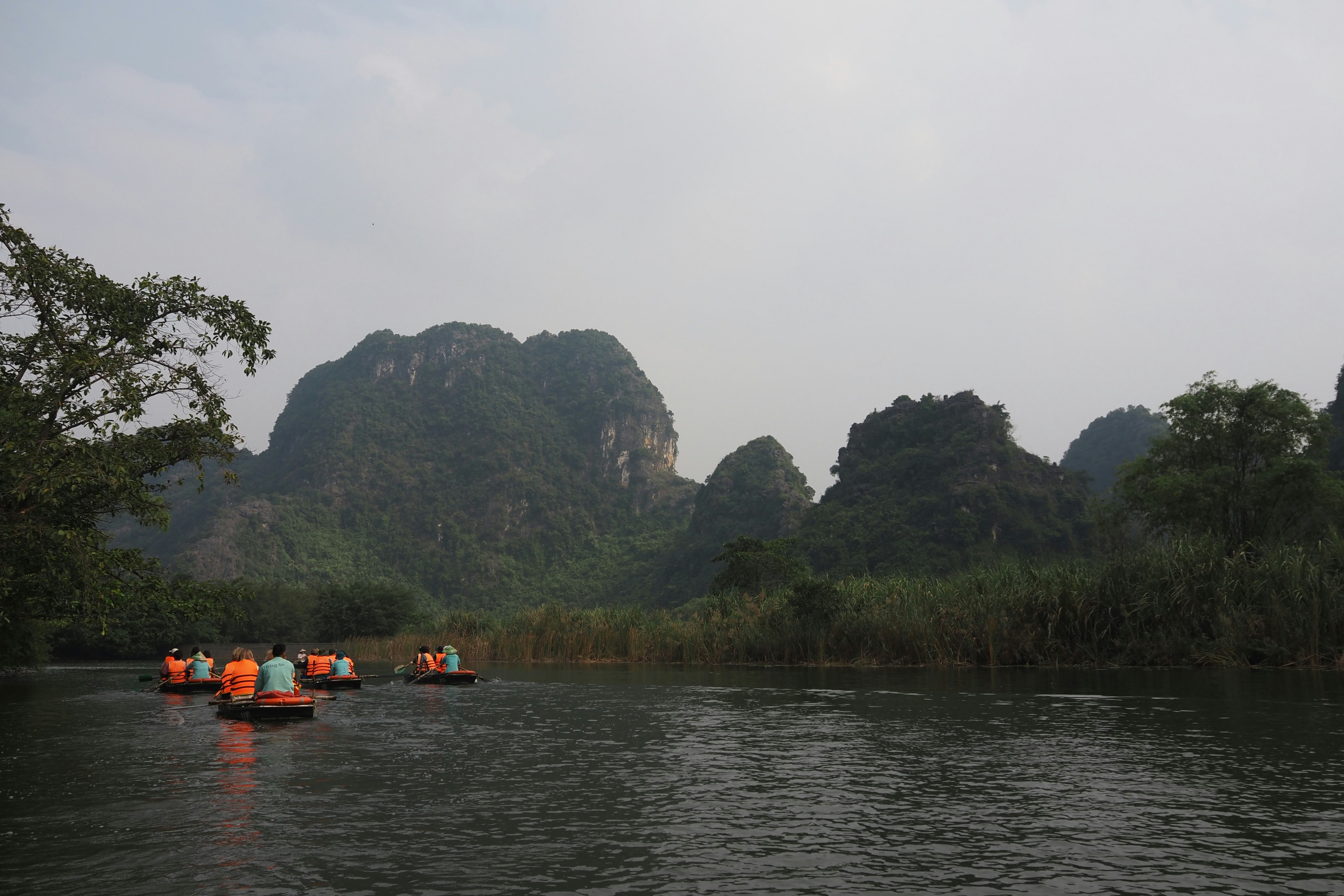 橙色槳葉的皮划艇在河上前行，山谷風景