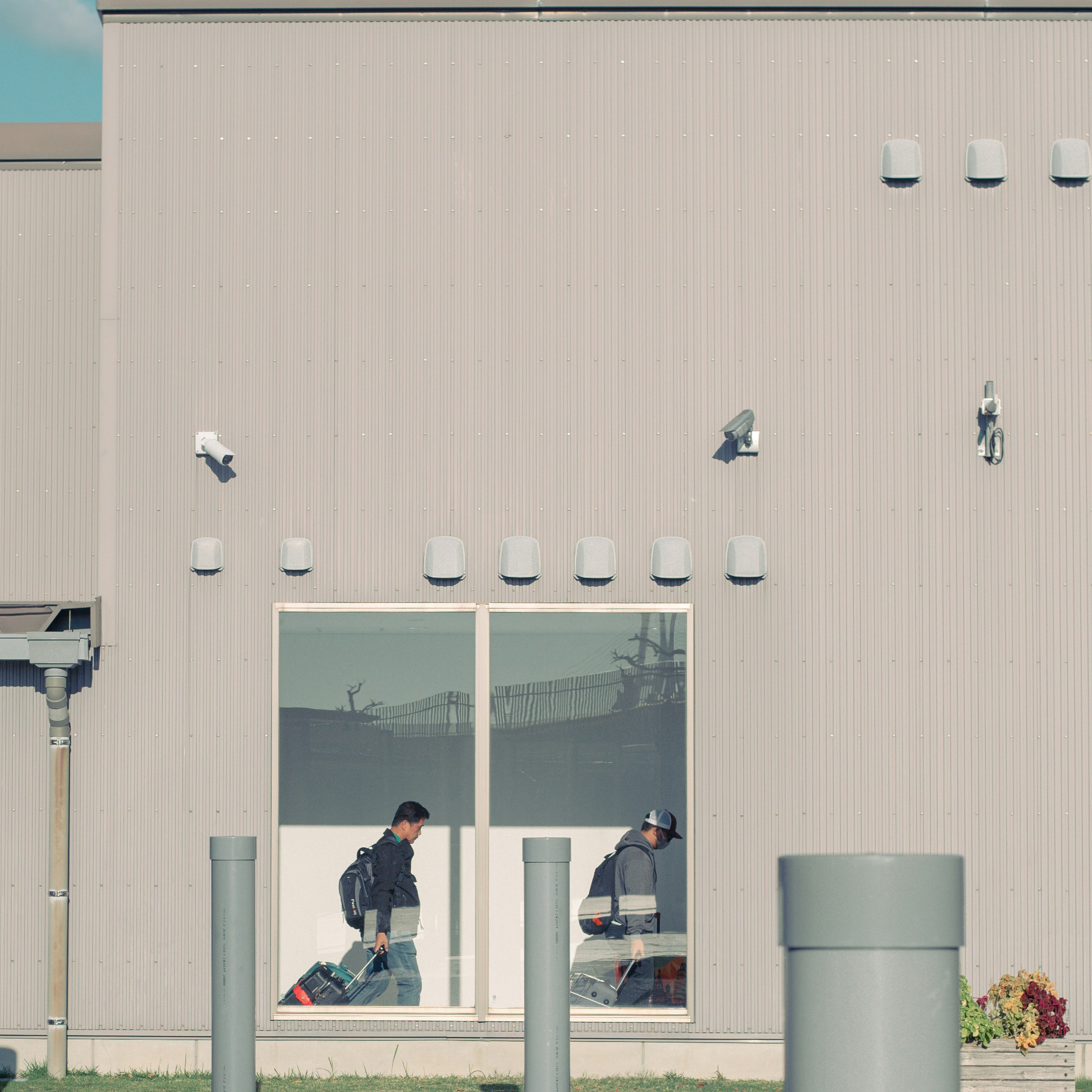 industrial building exterior with workers visible through open windows