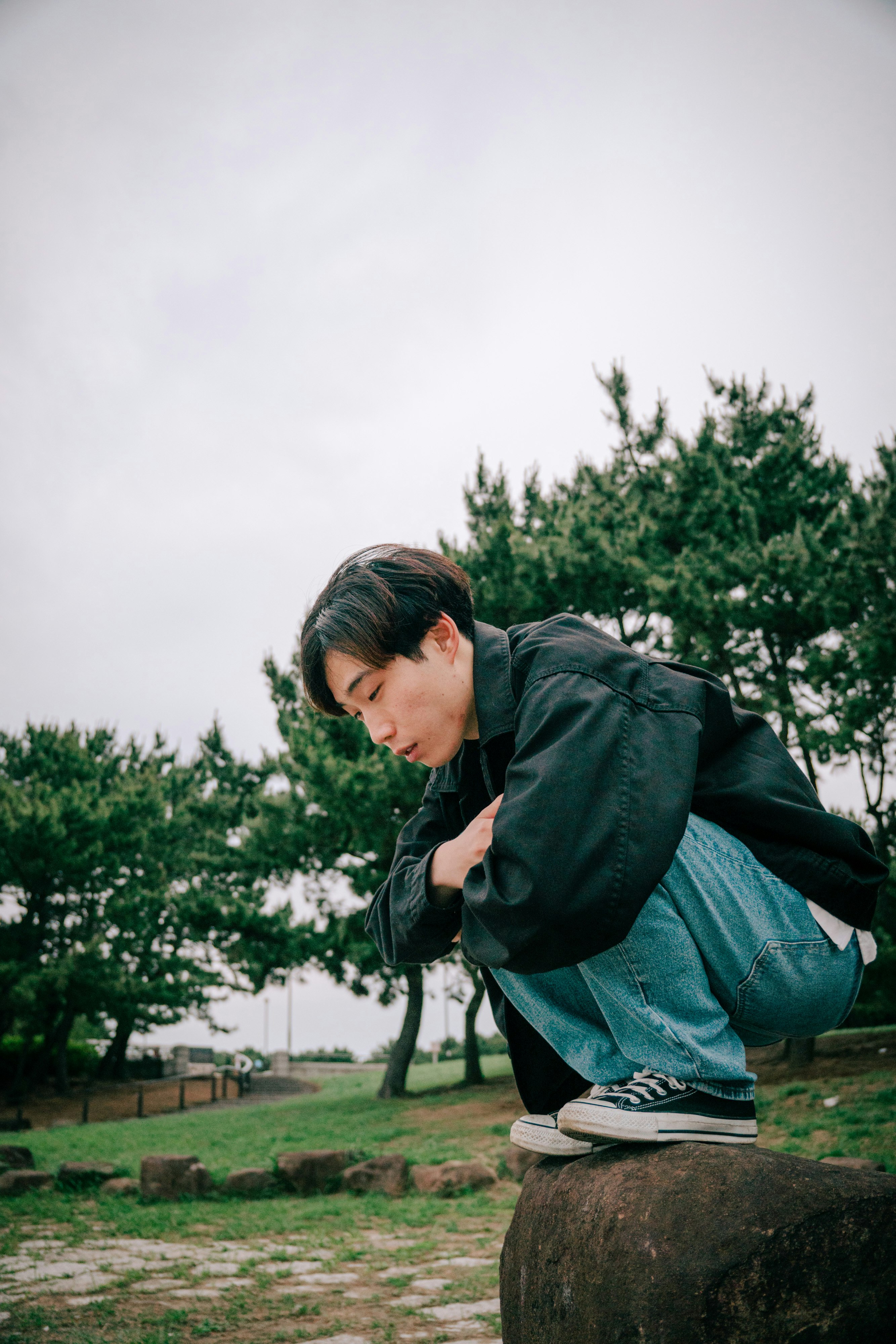 man sitting on a park bench tying his shoelaces