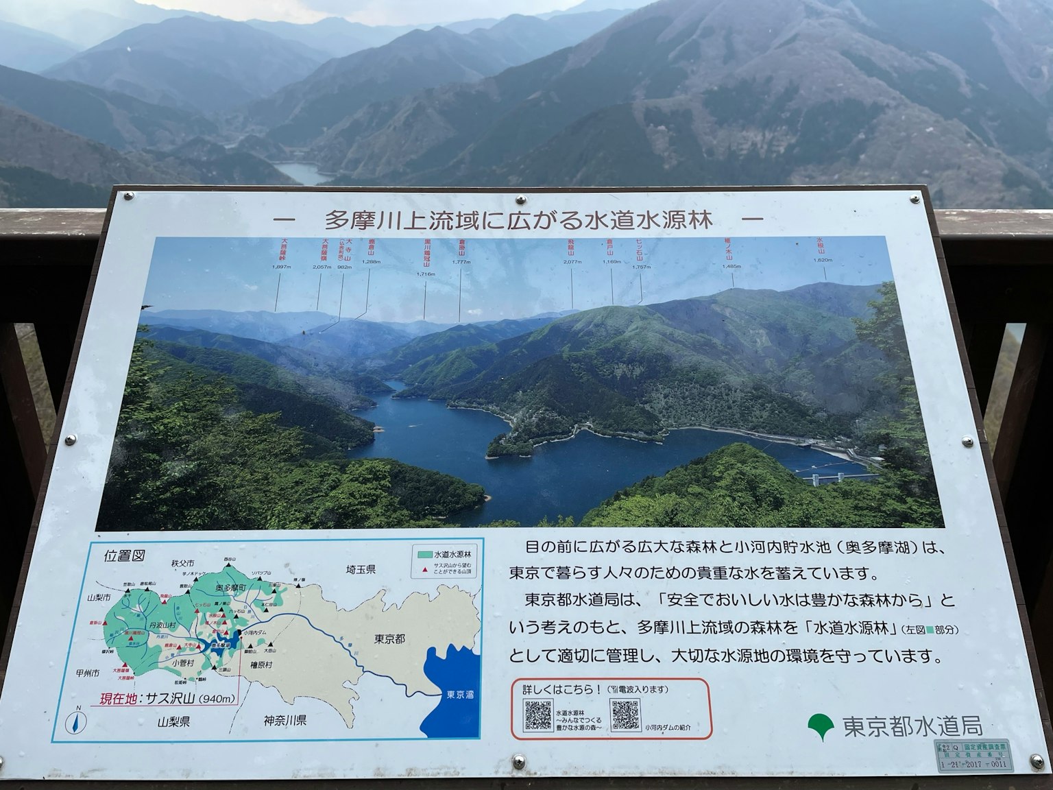 Scenic information board overlooking mountains and a lake