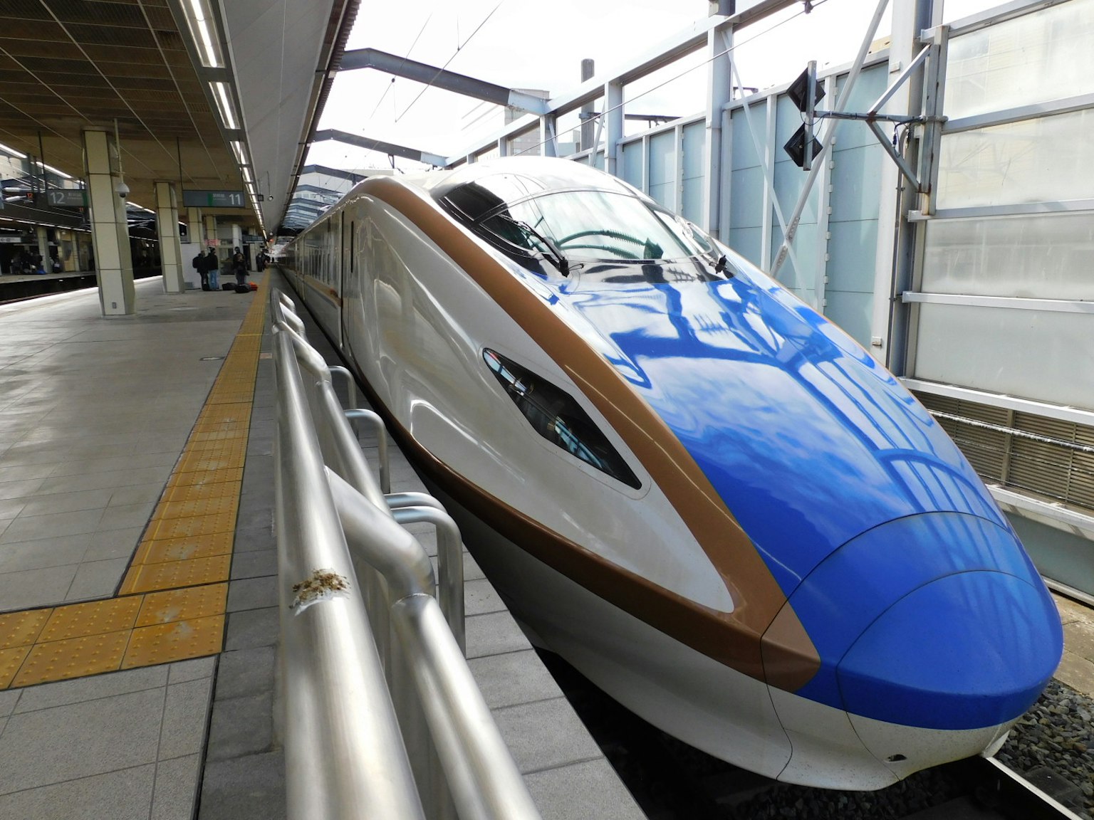 Tàu Shinkansen màu xanh tại sân ga