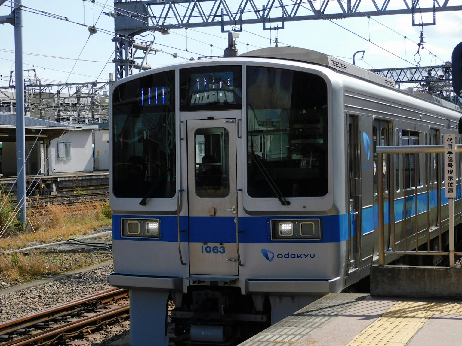 รถไฟที่มีแถบสีน้ำเงินจอดอยู่ที่สถานี