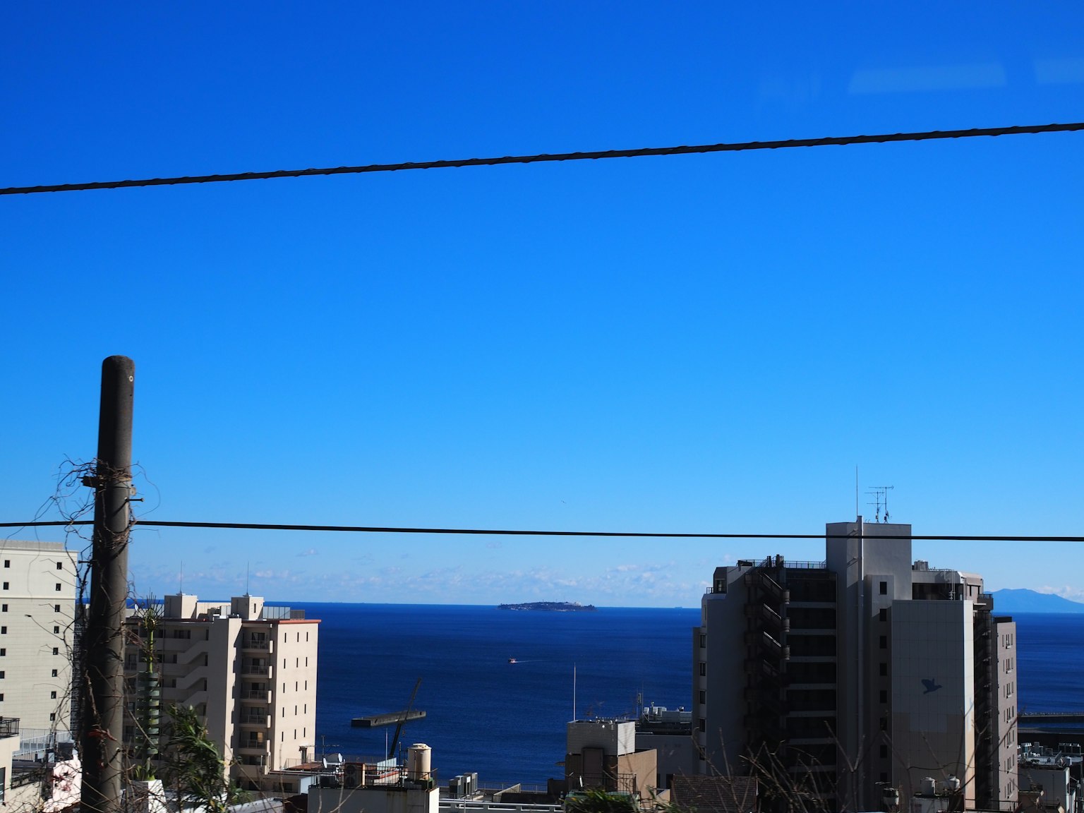 Imagen de paisaje urbano con cielo azul y océano