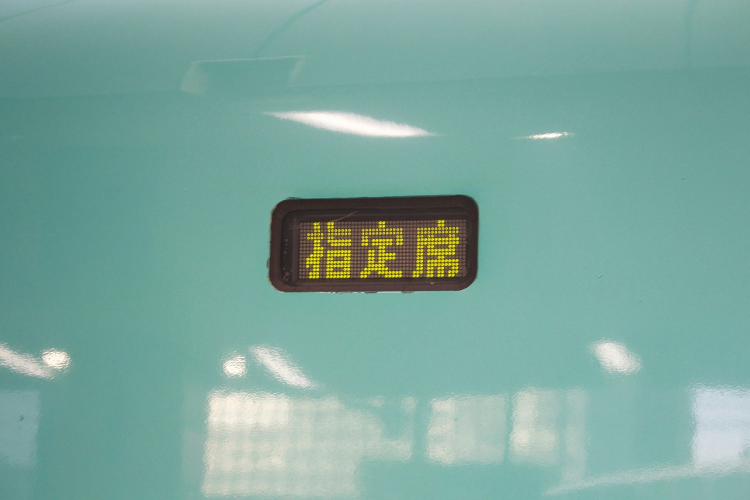 Señal que indica un asiento reservado con texto amarillo sobre un fondo verde