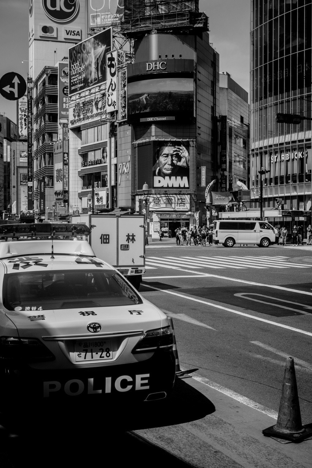 渋谷の交差点で警察車両と街の看板が並ぶ風景