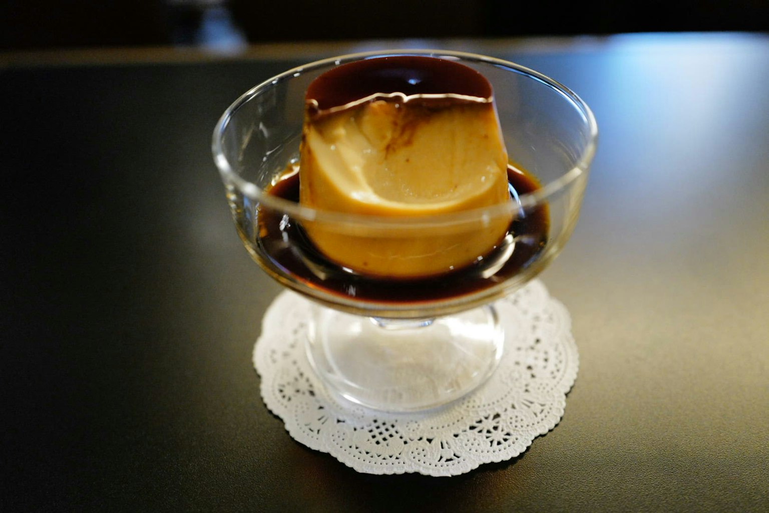 カラメルソースがかかったプリンが透明なグラスに盛られている