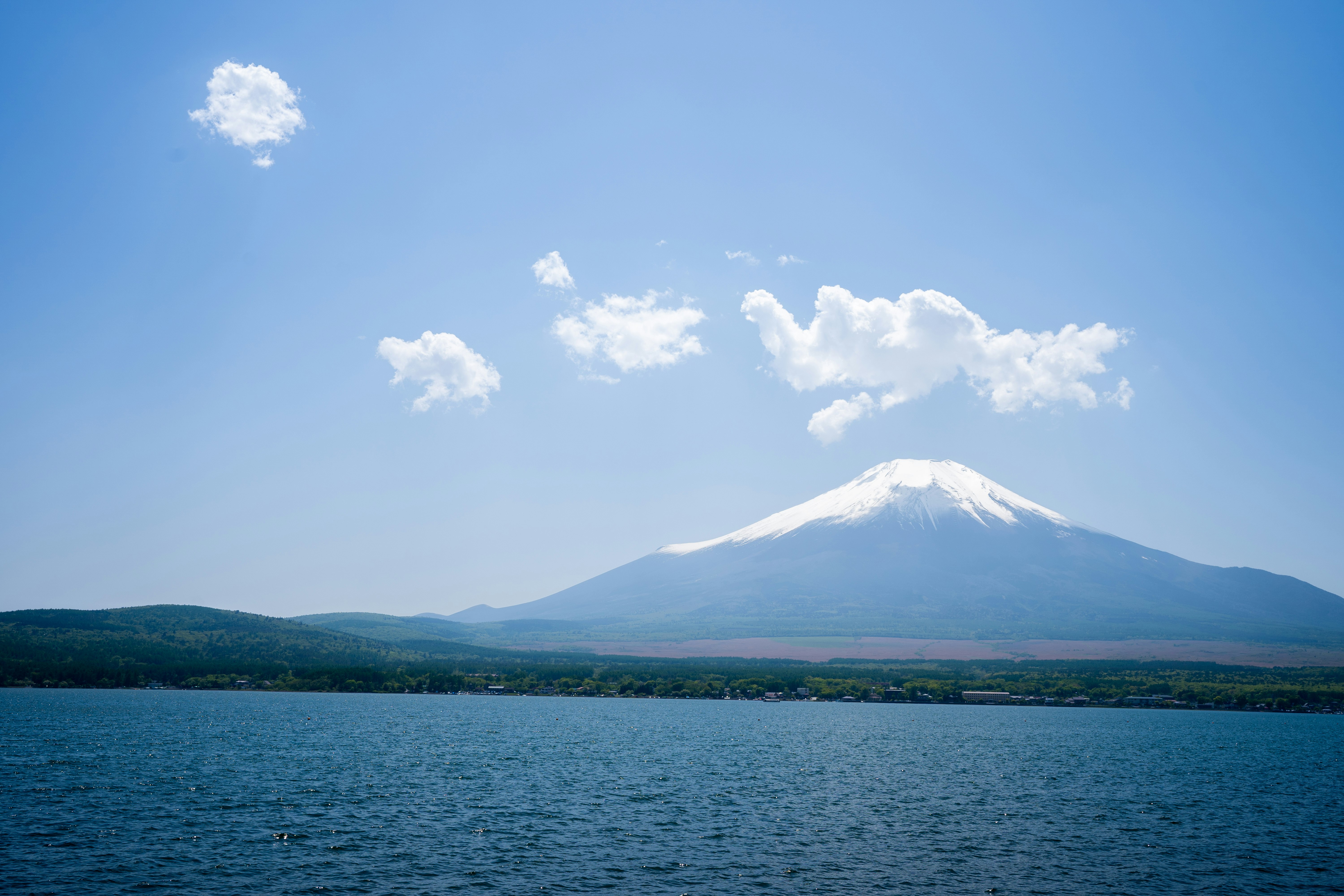 View of Mount Fuji under a clear blue sky with a lake