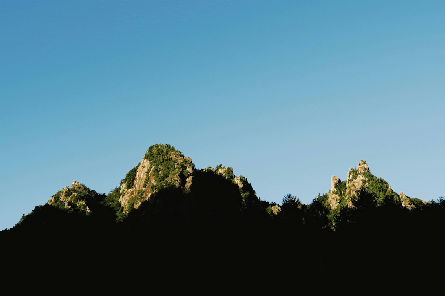 Silhouette of mountains under a blue sky