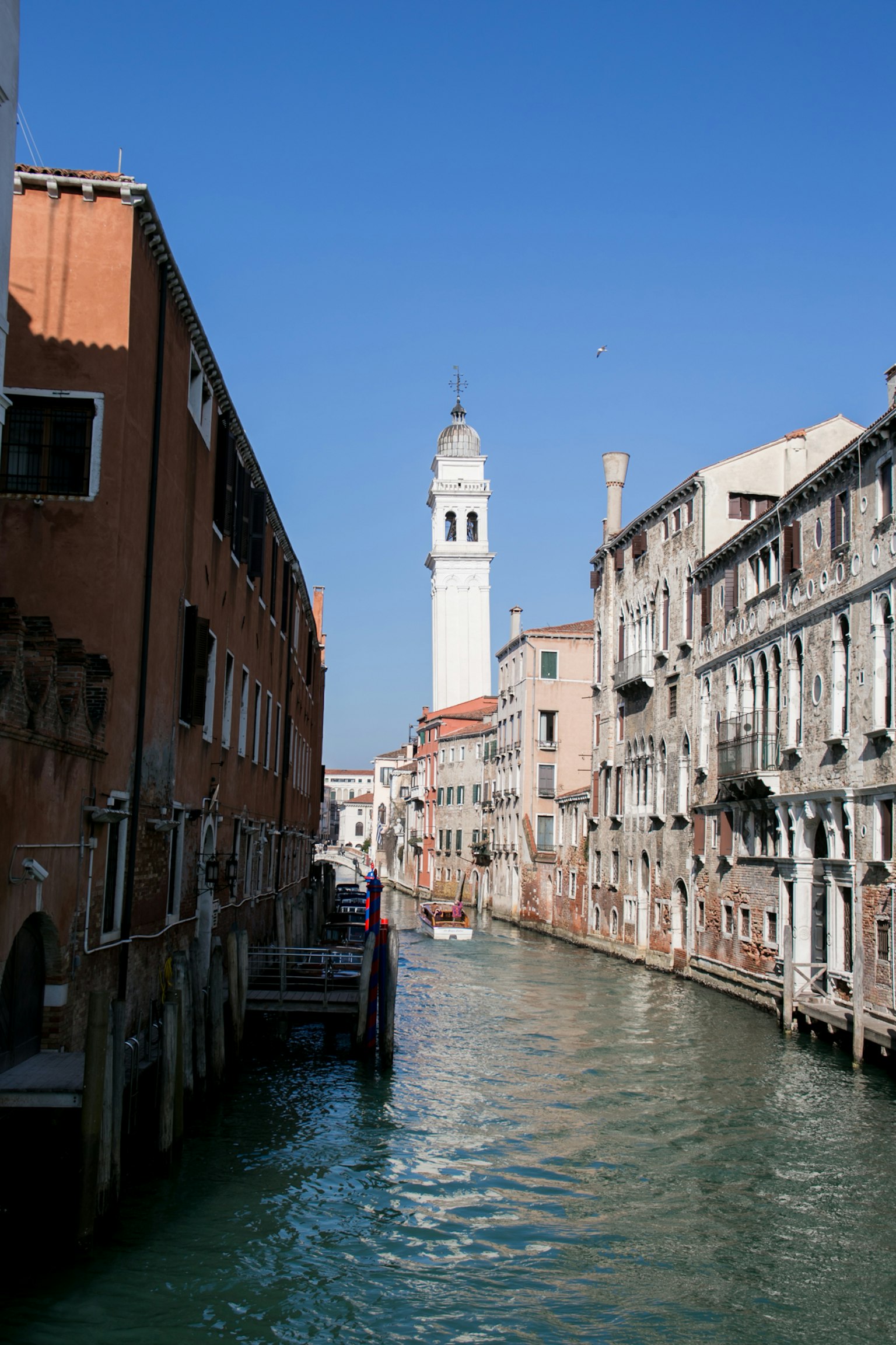 Blick auf einen Kanal in Venedig mit historischen Gebäuden unter klarem blauen Himmel